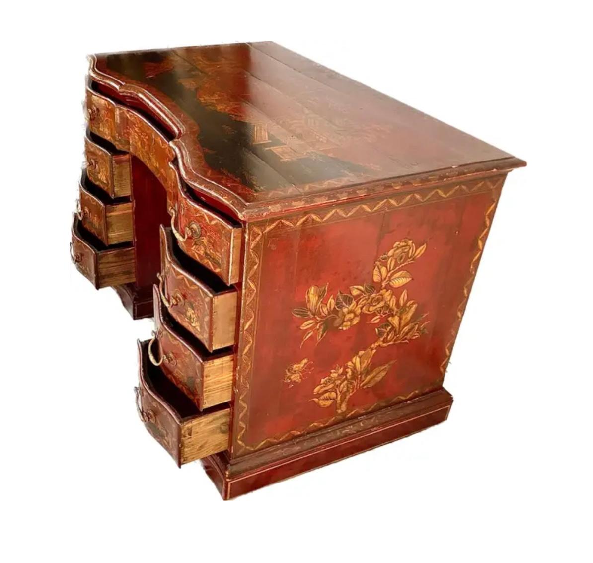Chinoiserie-Knielochschreibtisch aus dem 19. Jahrhundert (George III). Die vergoldete Chinoiserie befindet sich auf einem rot lackierten Hintergrund. Verzierte Klammerfüße stützen die drei zentralen Schubladen, die von drei passenden Schubladen