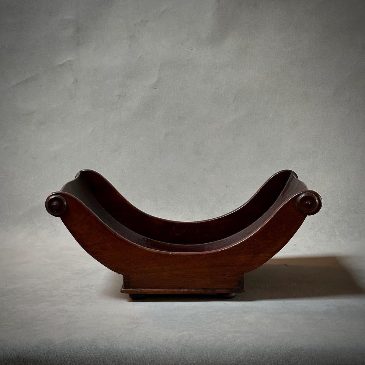 Ce sous-verre à fromage en bois géorgien, doté de poignées à volutes délicatement sculptées, rayonne d'une élégance intemporelle grâce à sa patine riche et profonde. Fabriqué en Angleterre vers 1810, il allie fonctionnalité et charme décoratif, ce