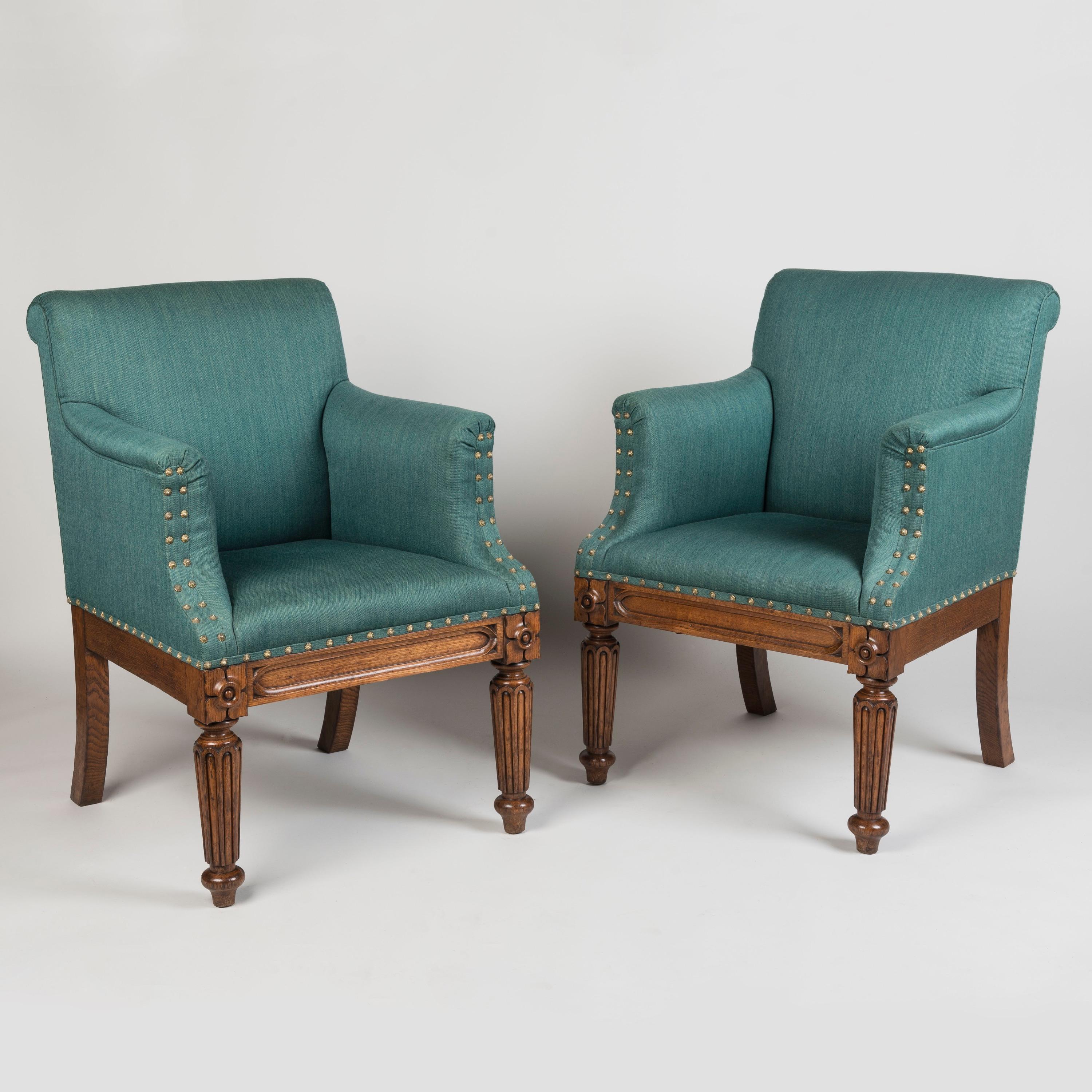 A pair of George IV Period armchairs
In the Manner of Gillows

The oak construction of gentle patination, with sabre legs to the rear and tapering turned reeded front legs; the apron decorated with ogee-ended panelling and carved quatrefoil