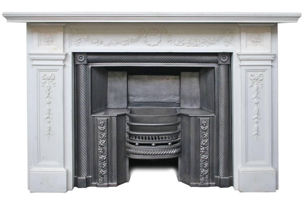 Restored antique George IV statuary white marble fireplace surround with finely carved decoration of ribbons and flowers to the legs, frieze and capitals, circa 1820.

Measures: Shelf 73