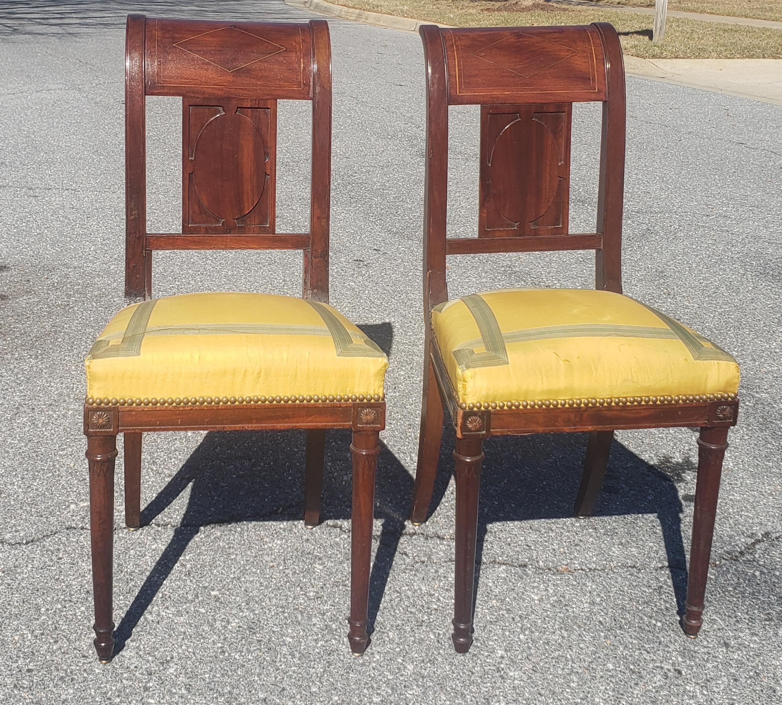 A rare pair of continental mahogany and brass inlay upholstered side chairs attributed to the famous French cabinet maker Georges Jacob. Very firm, reupholstered seats with springs. We have a total of 4 in our inventory, two separatedly listed as