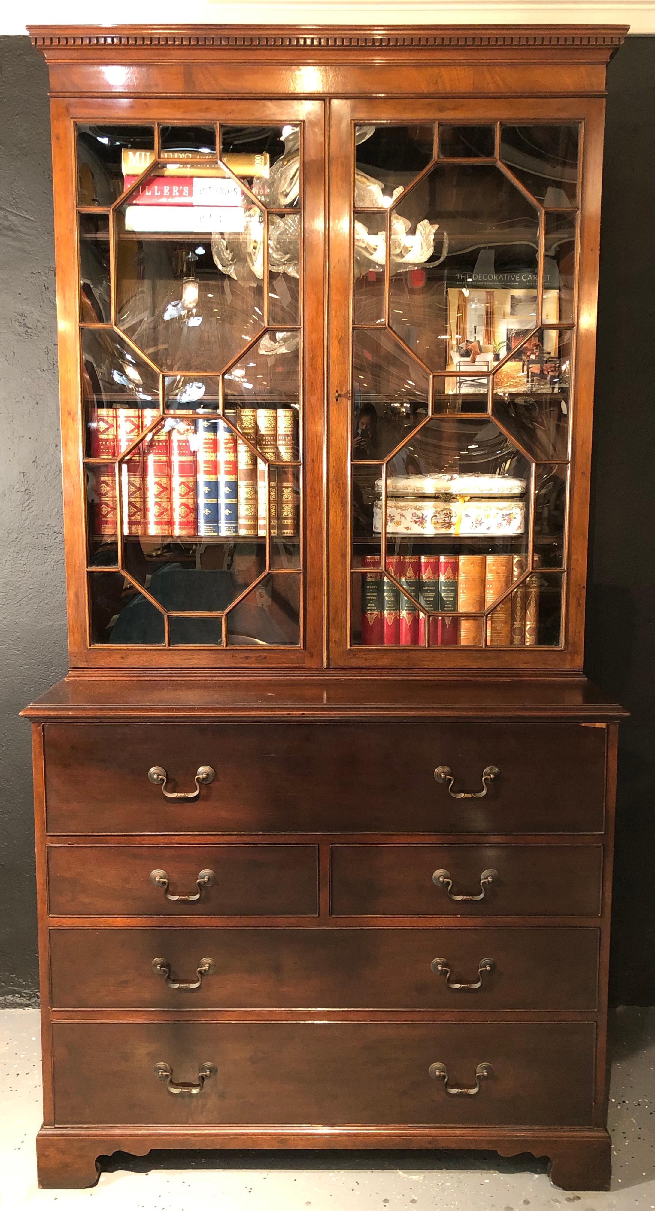 19th century George lll Style Butler's Secretary. This fine deep mahogany colored desk is simply stunning having Dentil molding above Mullion glazed doors sitting atop a desk and chest of drawers.
In a desirable rich deep colored mahogany finish,