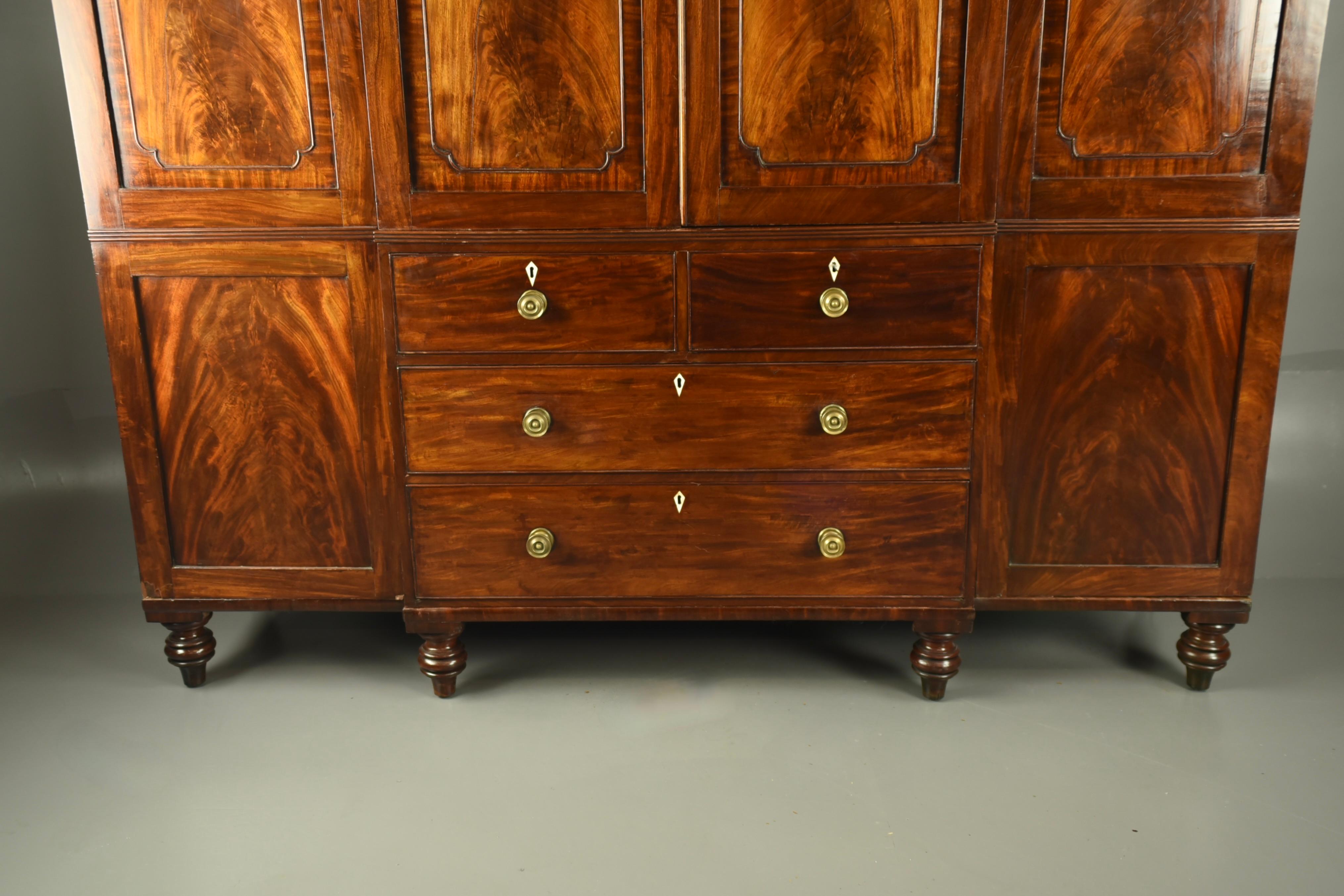 Fine quality Late Georgian mahogany compactom wardrobe .
The wardrobe has a fully fitted centre section with slide out trays that can be removed to create additional hanging space below this there are two small over two large oak lined drawers .