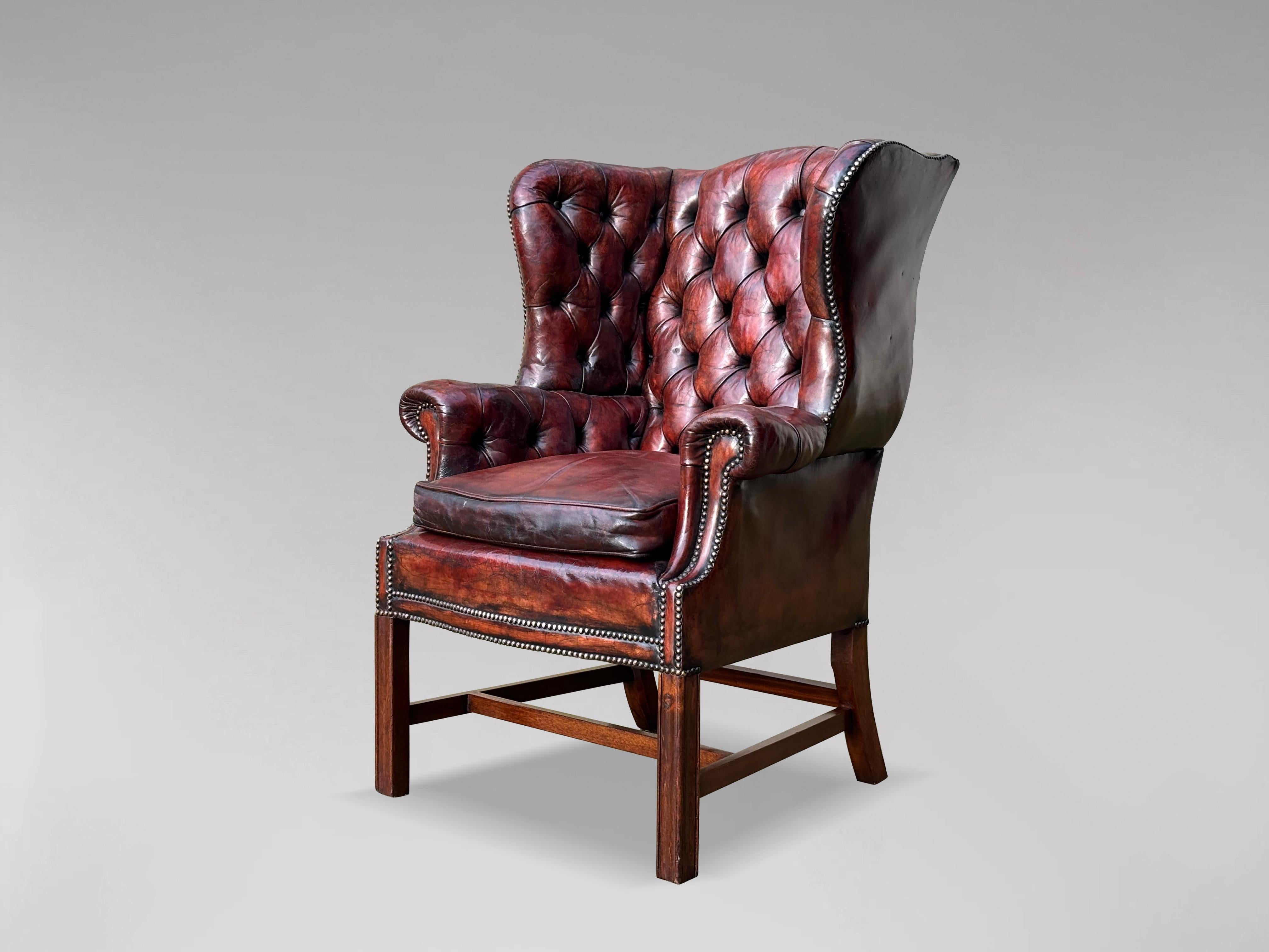A good quality late 19th century burgundy brown leather wing armchair, George III style shape with square tapering legs, H-frame stretchers, with buttoned back and loose feathered cushion. Lovely patina and very comfortable.

The measurements
