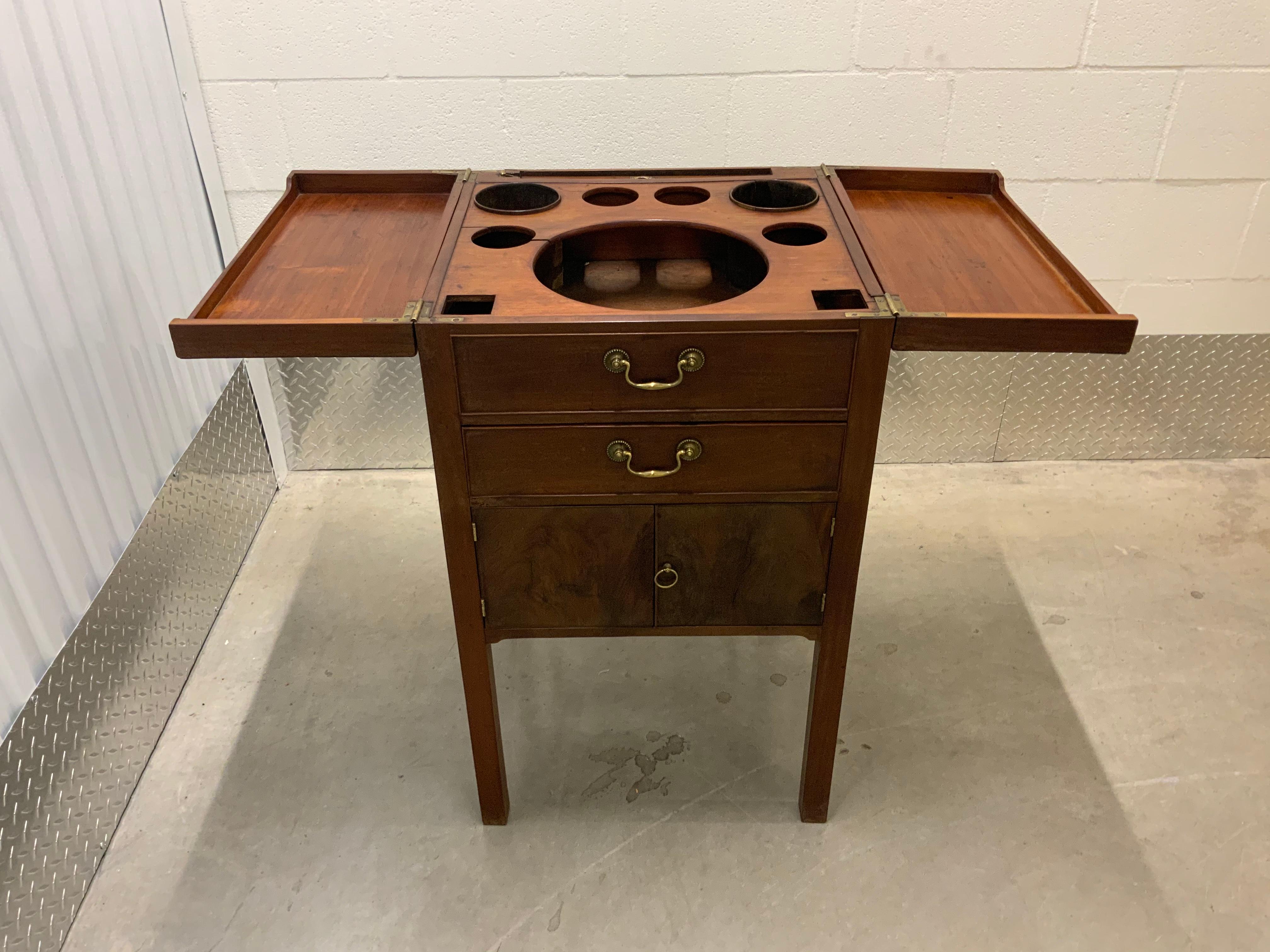 Georgian Gentleman’s Mahogany wash or basin stand 1795-1810. This is a very well constructed piece with all case and drawer pieces nicely dovetailed together including the mirror frame and the hinged lids. The retractable mirror lifts up with a ring