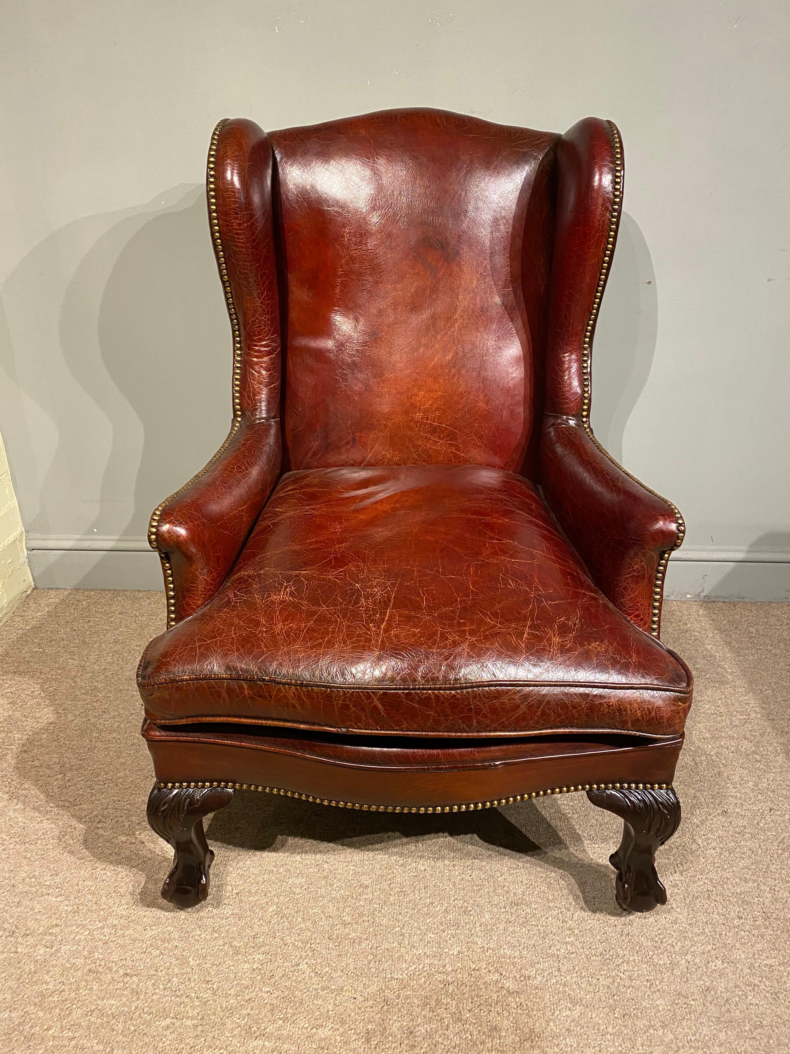 This is a stunning quality 19th Century Georgian Style Gentleman's Library Chair, made by one of England's finest furniture makers of the Victorian period - Lamb's of Manchester. The beautifully shaped leather and brass studded wing back chair has a