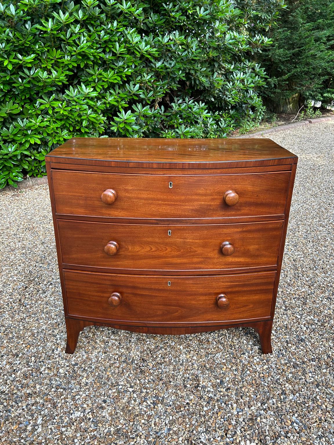 19th Century Georgian / Regency Mahogany Bowfront Chest Of Drawers, with three long graduated oak lined drawers with round turned bun handles, on splayed feet.

Circa: 1820

Dimensions:
Height:  36 inches – 91 cms
Width:   36 inches – 92 cms
Depth: 