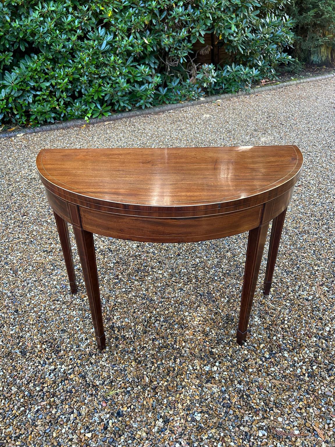 A high quality 19th Century Georgian Mahogany Inlaid Demi Lune Card Table with a folding top lined with a green baize, crossbanded and line inlaid decoration on square tapering legs with spade feet.

Circa: 1820

Video:
If you require video. Please
