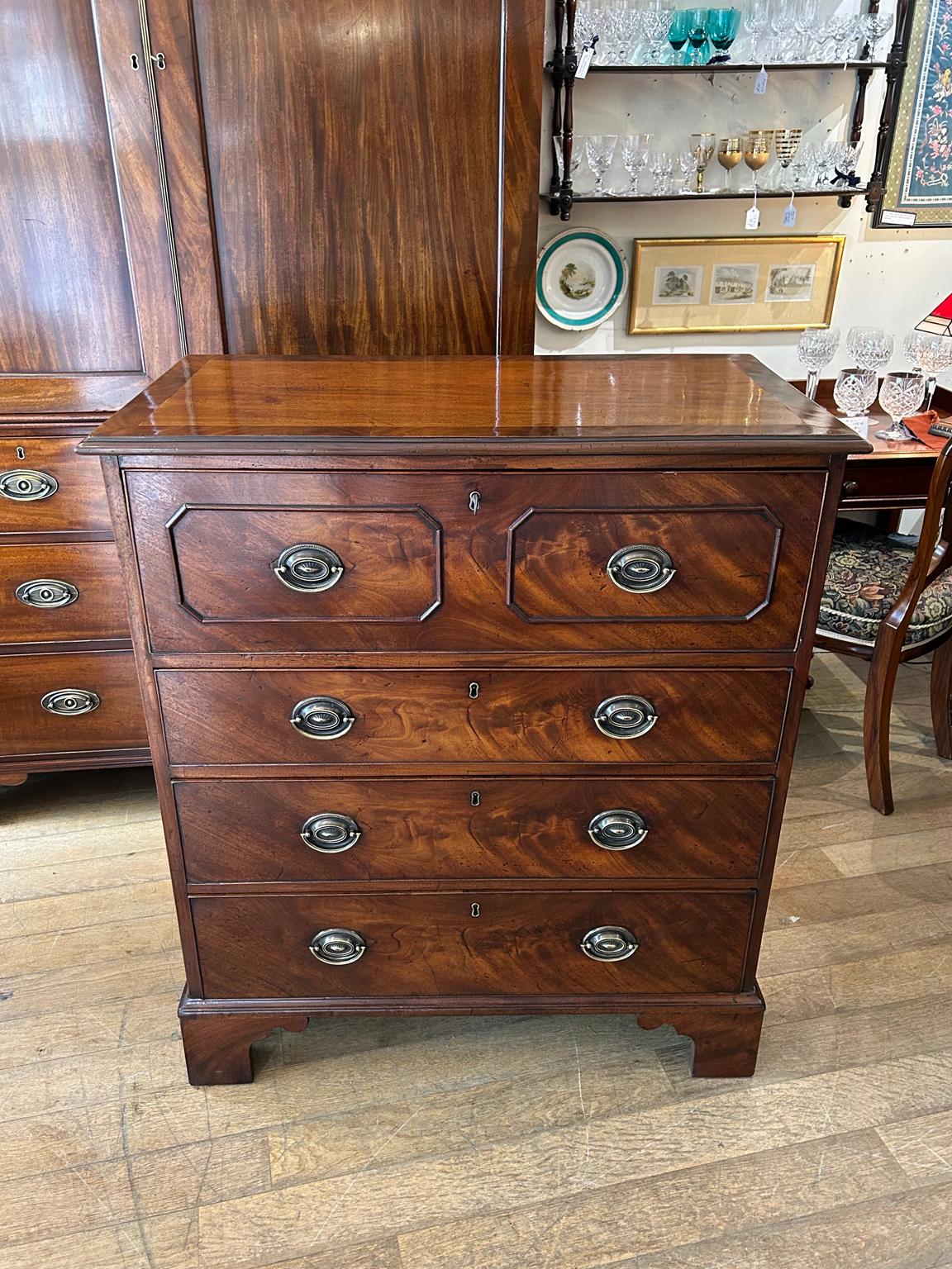 19th Century Georgian Mahogany Secretaire has a fitted desk drawer over three long drawers with brass oval handles. The fitted desk drawer interior has a writing surface with 7 strung drawers and 5 pigeon holes. Stands on four bracket feet.

Circa: