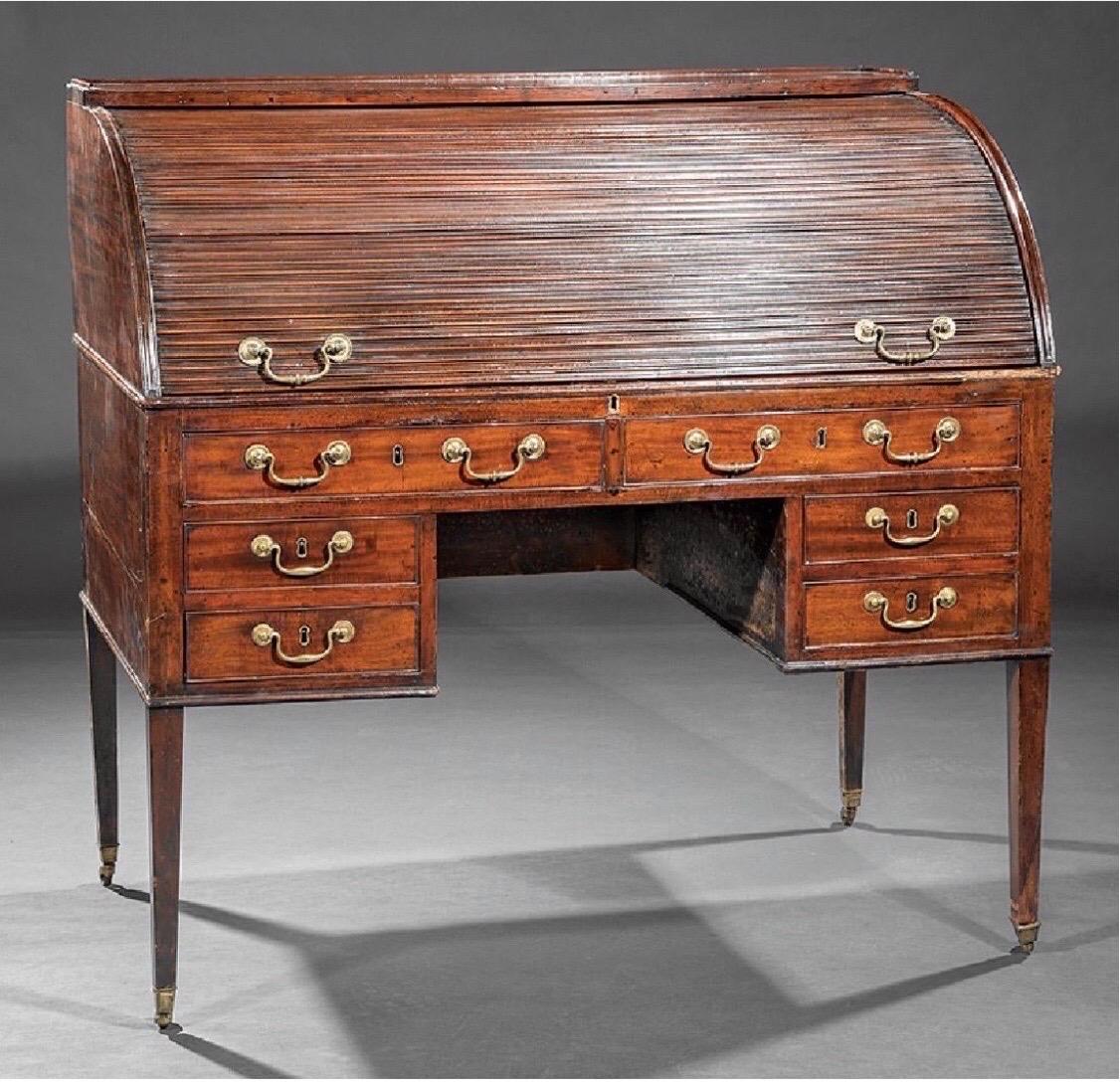 Late 18th-early 19th century Georgian mahogany tambour desk with green tooled leather writing surface, fitted interior, tapered legs and original castors.

 