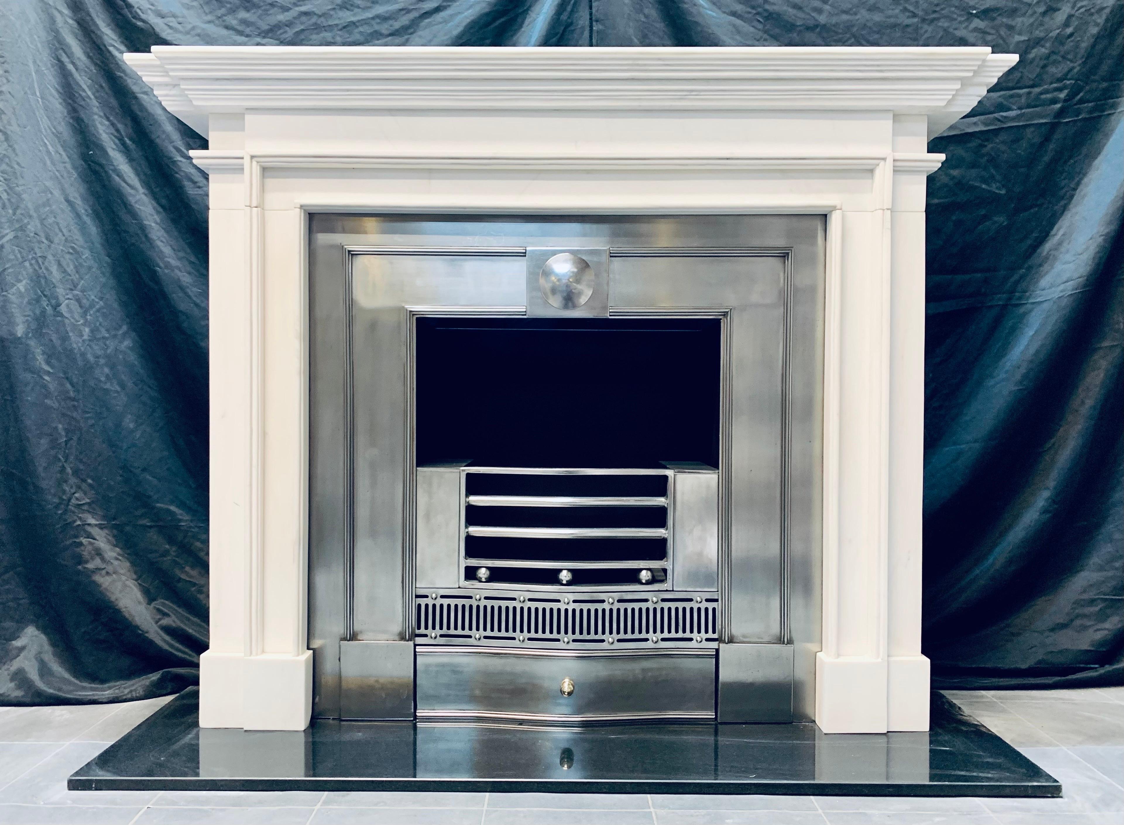 A 19th Century Georgian Manner lightly veined statuary marble fireplace surround of good proportions. A deep break-front top shelf with channelled under moulding sits directly above a connecting frieze with raised moulding forming a framed aperture,