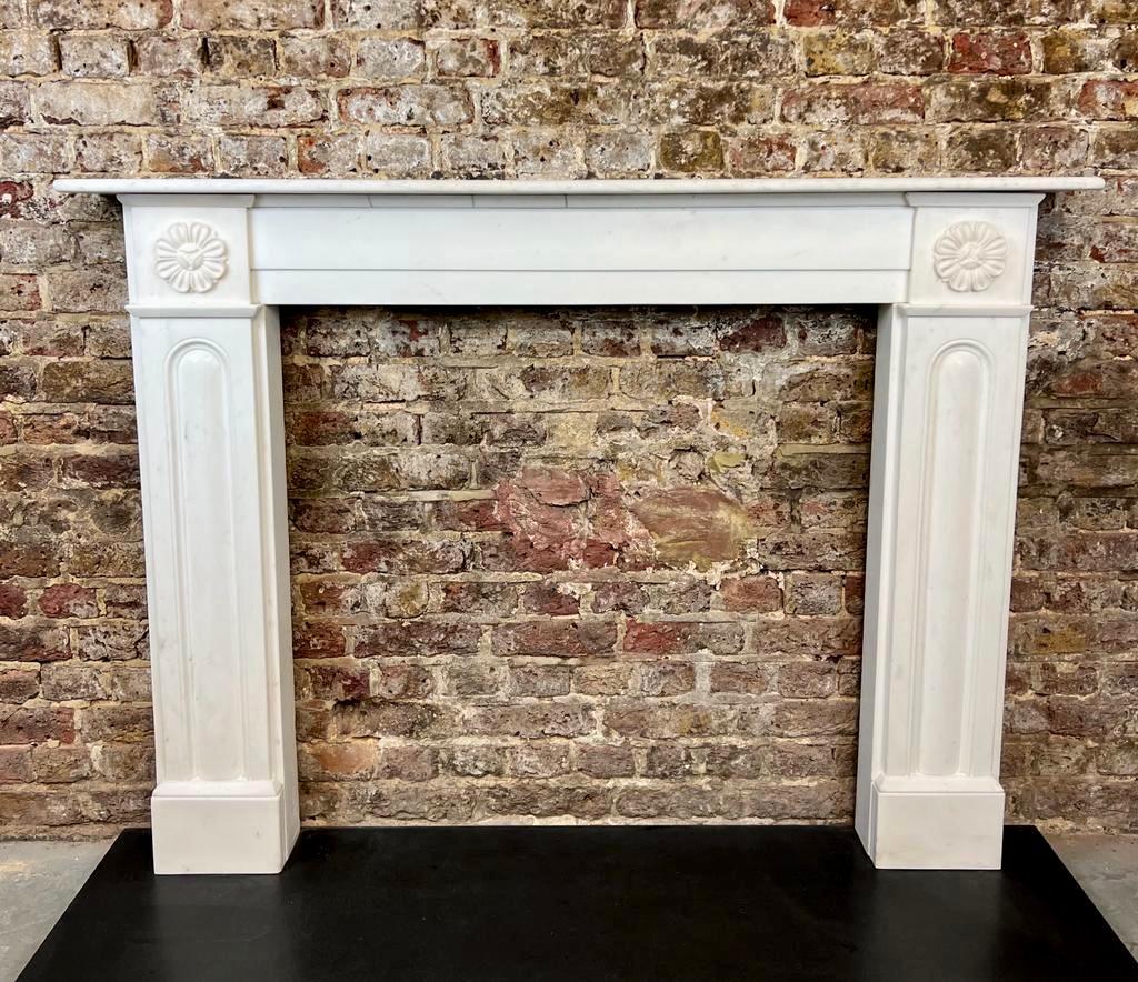 19th Century Georgian Marble Fireplace Mantlepiece.
An Extreemly Fine Hand Carved Fireplace Surround, Made From Italian Statuary White Marble. 
With Hand Carved Panels Detailing To Each Jamb And Pair Of Floral Petel Carvings Surmounted Above.