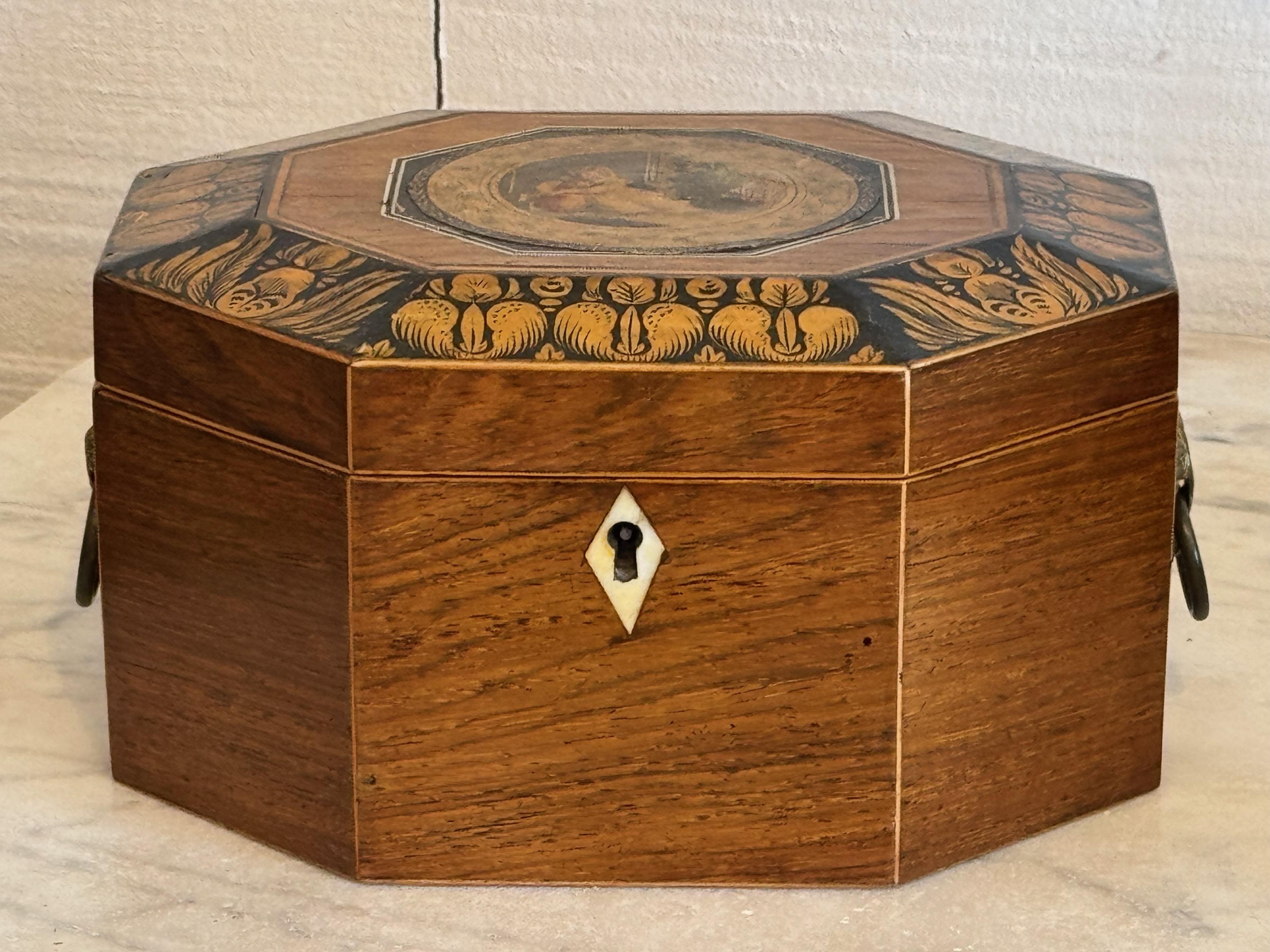Caja georgiana del siglo XIX de forma octogonal, con delicada decoración calada en la tapa con un medallón central en forma de retrato y motivos florales. El interior está provisto de una bandeja extraíble forrada de rojo y conserva un escudo de