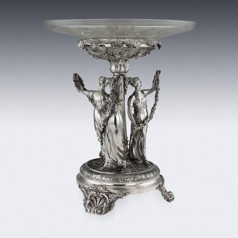 Antique early 19th century Georgian Monumental solid silver figural centerpiece, raised on three cast scroll and shell feet, the base is applied with a very crisp scrolling foliate decoration in relief, supporting three large and finely modelled