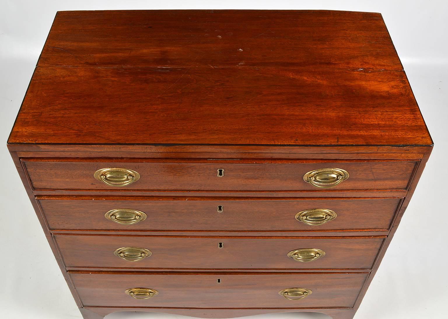 Of attractive small proportions this fine Georgian mahogany chest features a caddy style polished top above four graduated drawers retaining their original brasses and resting on a serpentine shaped apron on bracket feet.