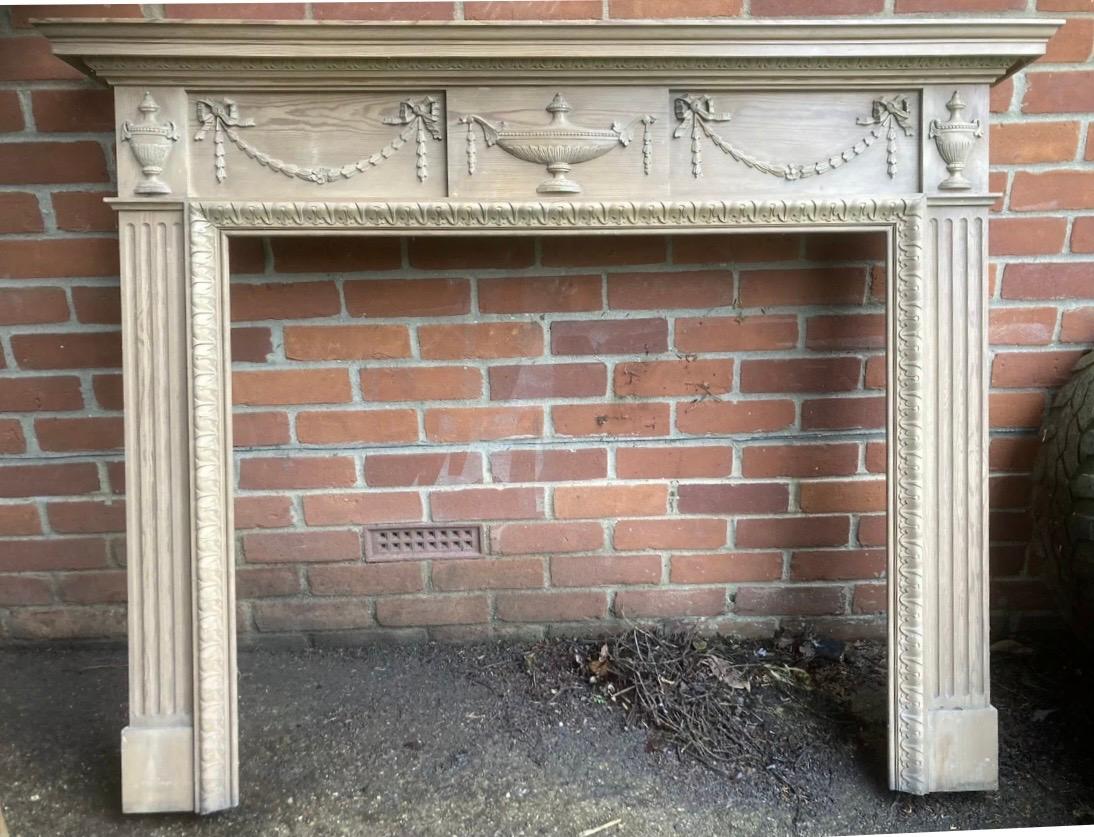 A charming and well proportioned Stripped clear Pine fireplace surround showing well executed carving in the 19th Century Georgian manner. An ogee and stepped top shelf over a frieze comprising a central tablet showing a large carved high relief