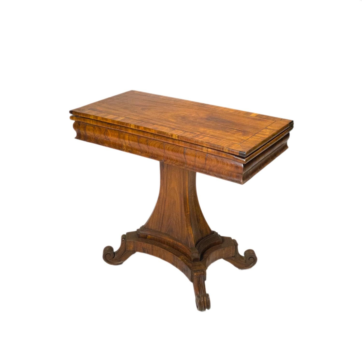 A superb walnut turn over leaf card table with a hinged and molded top of rectangular form folding over to reveal fitted wooden playing surface, finely hand carved.