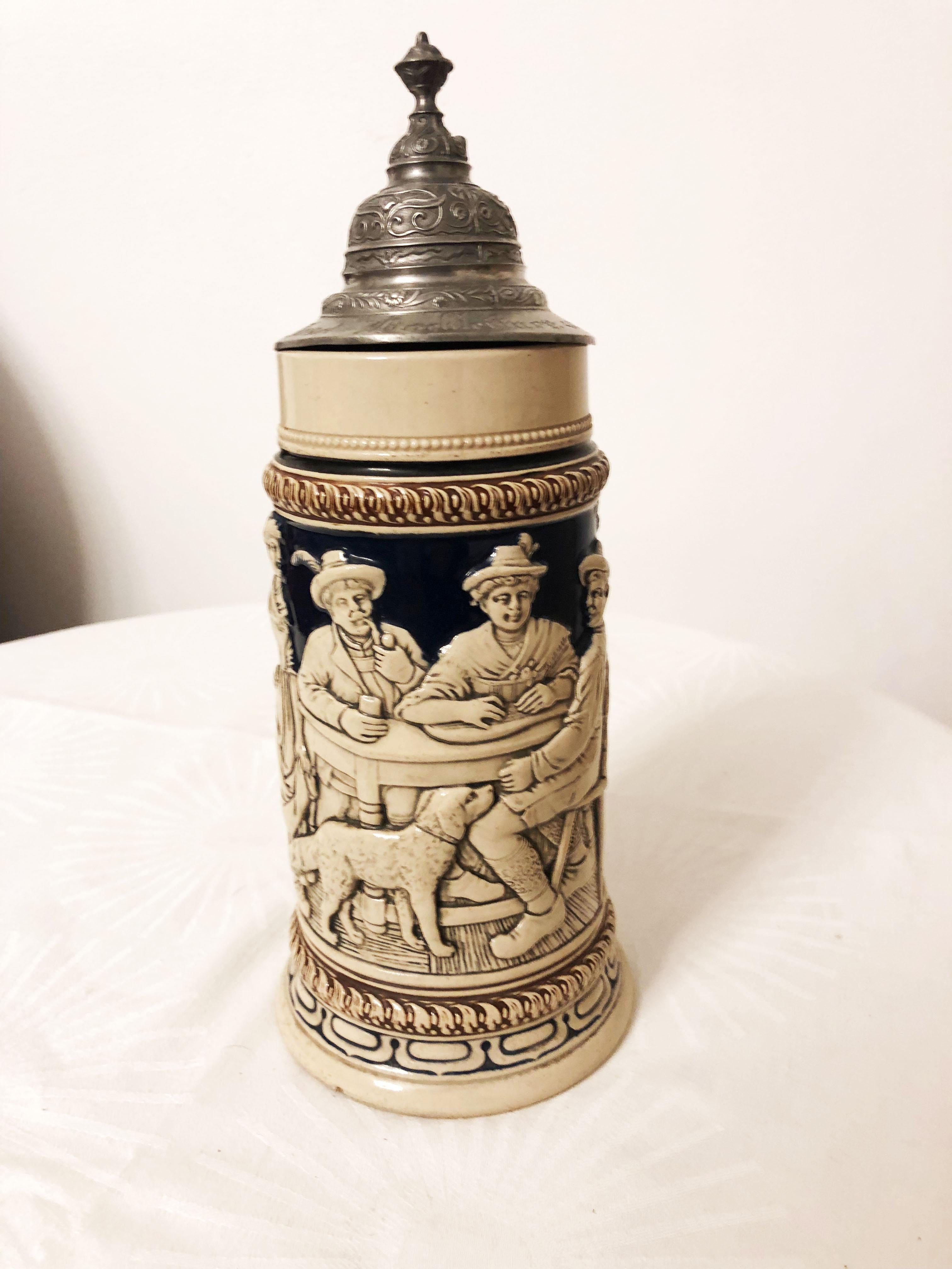 Stoneware 1/2 liter beer stein with an original pewter hinged lid. The body is decorated with a tavern scene.
Made in Germany, circa 1880.