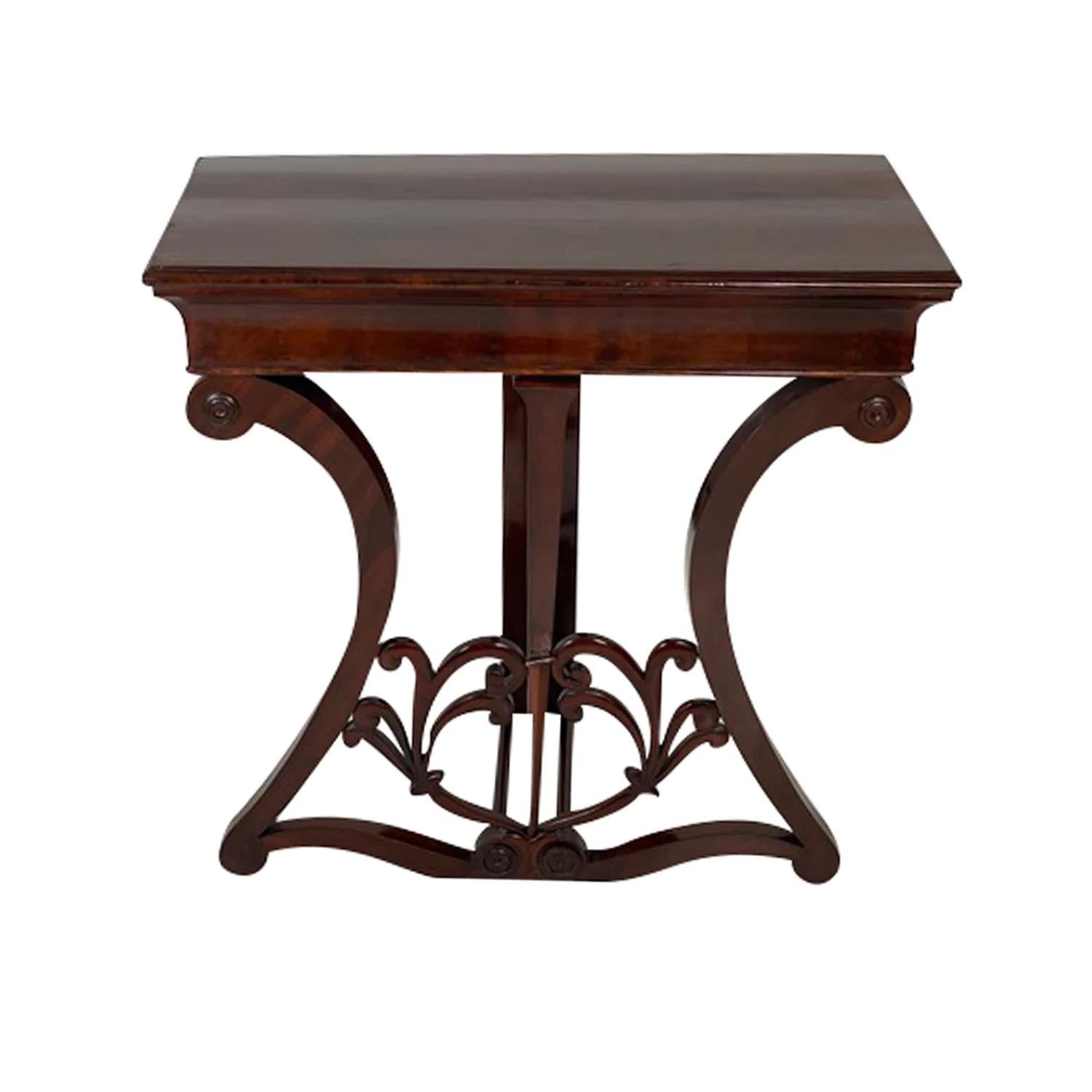 An antique German Biedermeier freestanding console table made of hand crafted Walnut, shellac polished and partly veneered in good condition. The particularized carved table is supported by a straight wooden leg, standing on two detailed arched