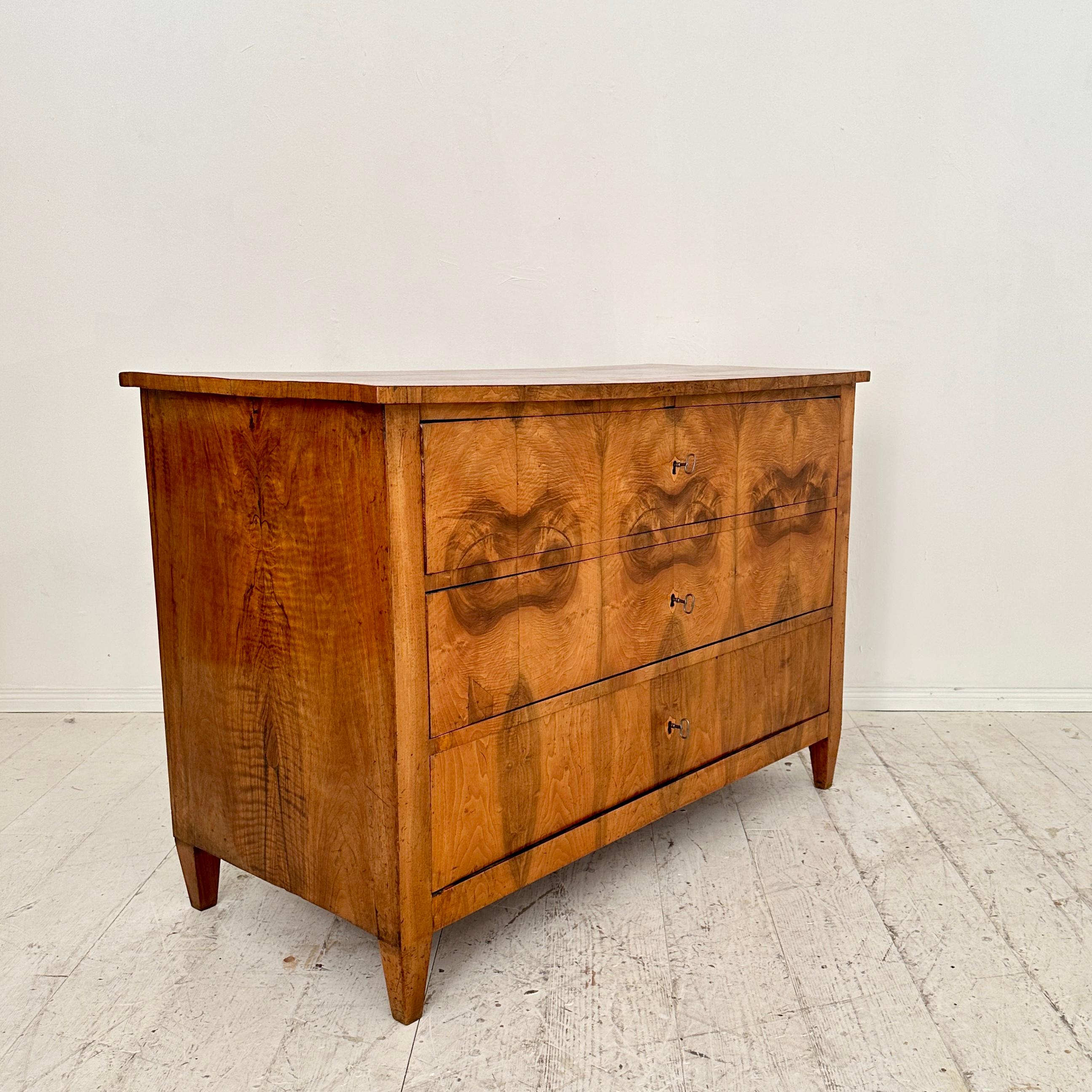 Crafted around 1820, the 19th Century German Biedermeier Chest of Drawers in Walnut with Three Drawers epitomizes the elegance and simplicity of the Biedermeier era. Made from rich walnut wood, this chest exudes a timeless charm, reflecting the
