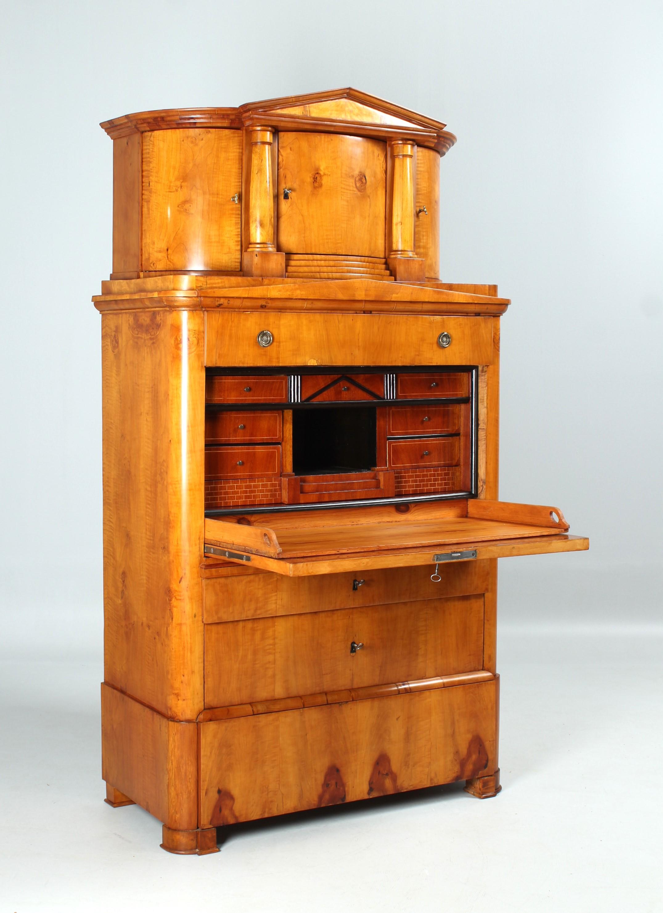 Antique top secretary from the Biedermeier period around 1830/1835.
Birch veneer with very subtle grain.

Architecturally structured interior with marquetry and band inlays. Extendable writing top in coniferous wood.

Structure with so-called