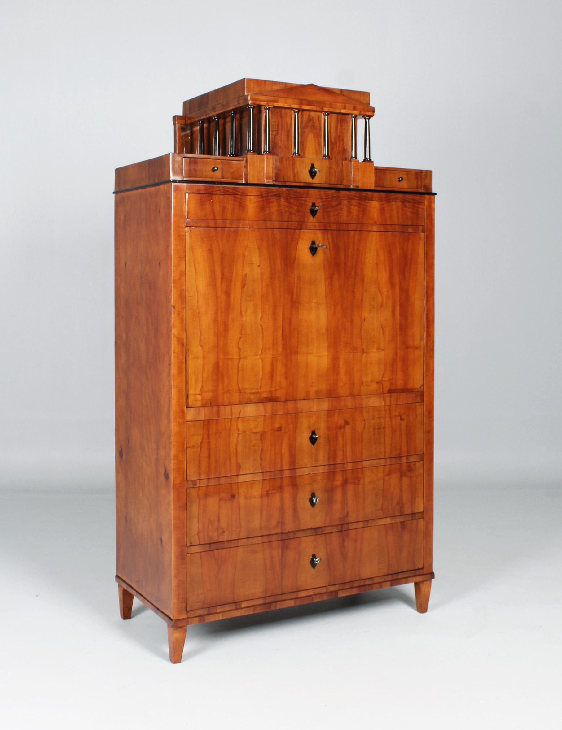 Writing cabinet with portico structure.

South Germany
Pear tree
Biedermeier around 1815

Dimensions: H x W x D: 174 x 95 x 49 cm

Description:
Strictly cubist piece of furniture standing on pointed legs and veneered in pear.

The