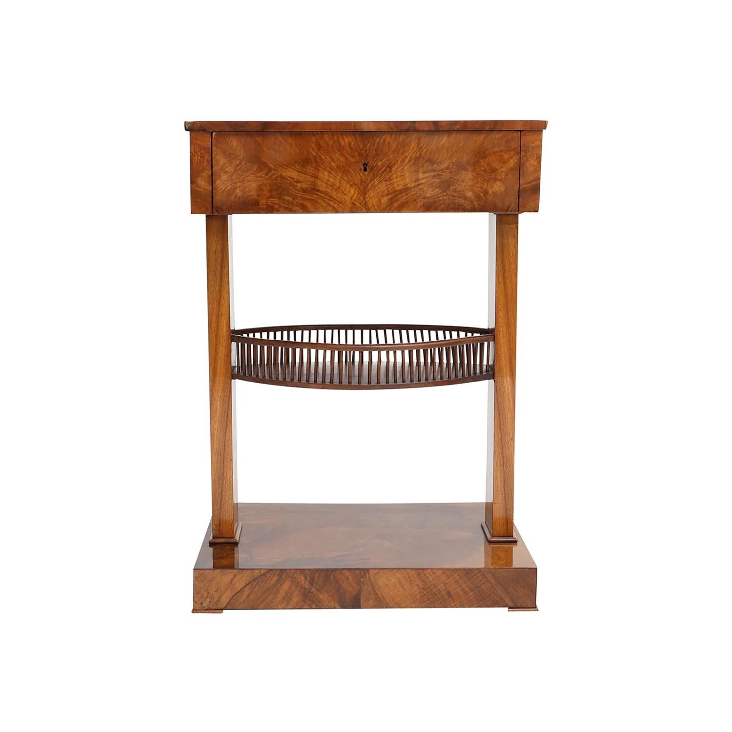 Ein antiker deutscher Biedermeier-Nähtisch aus handgefertigtem, schellackpoliertem, partyfurniertem Nussbaum, in gutem Zustand. Der kleine Beistelltisch besteht aus einer Schublade, das Innere ist mit drei kleinen und einem großen Ablagefach