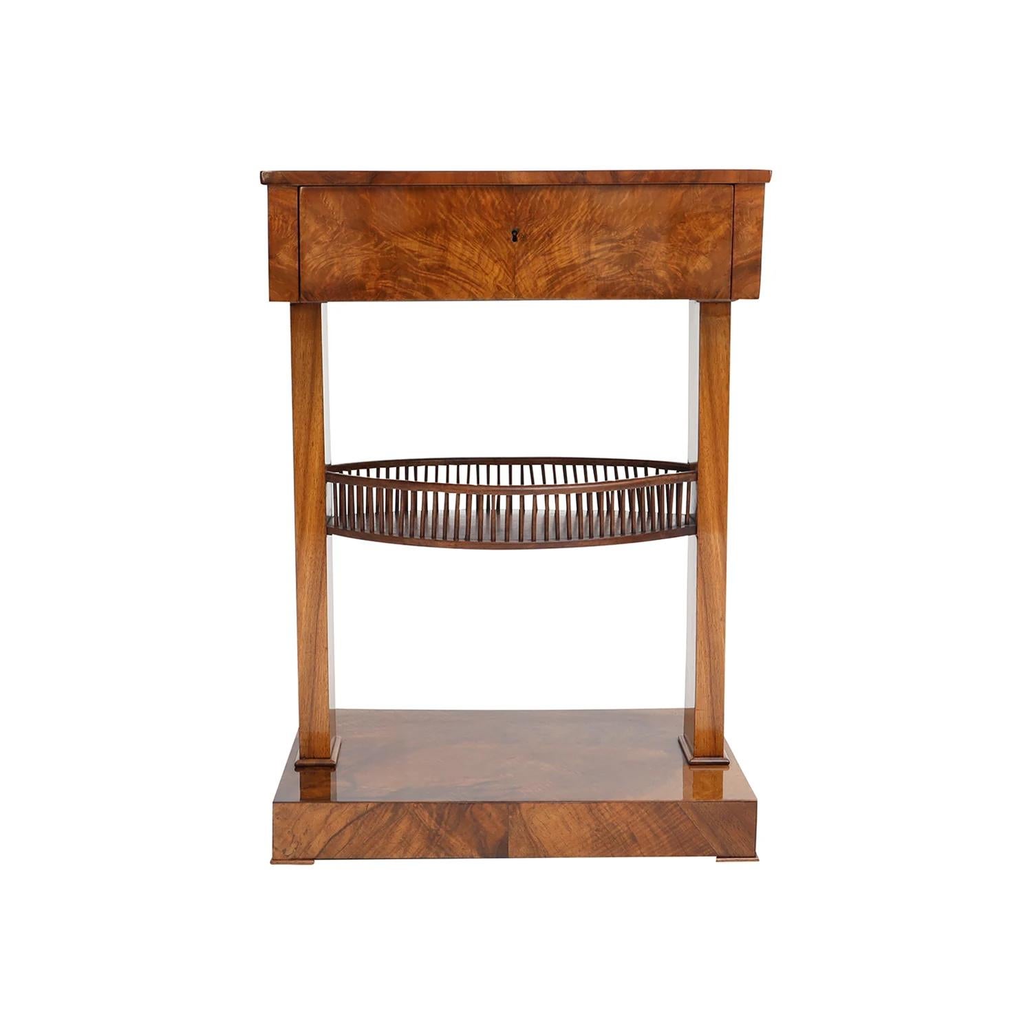 An antique German Biedermeier sewing table made of hand crafted shellac polished, party veneered Walnut, in good condition. The small side table is composed with one drawer, the inside is particularized with three small and one large storage