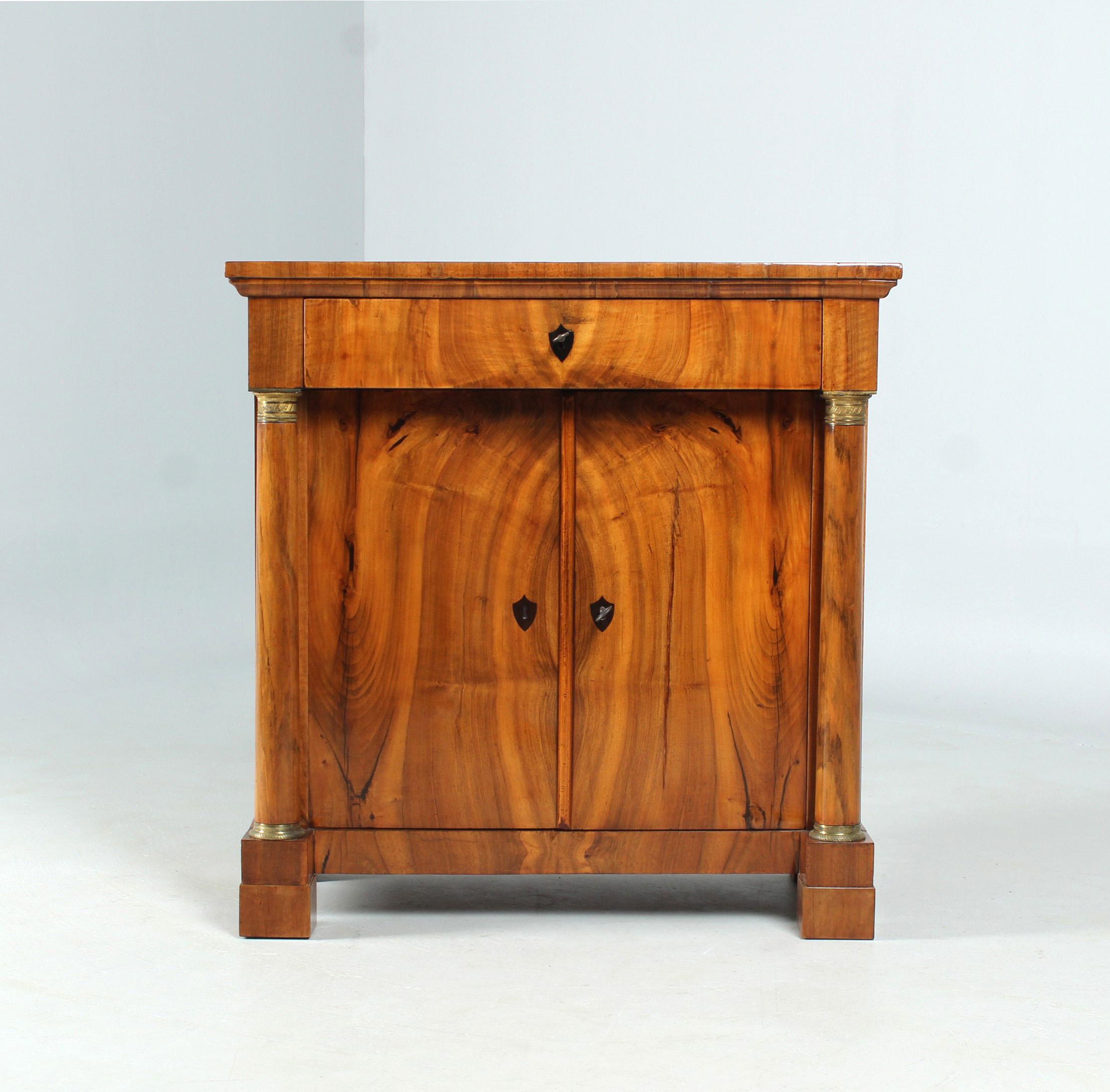 Biedermeier Sideboard

West Germany
Walnut
Biedermeier around 1825

Dimensions: H x W x D: 89 x 87 x 45 cm

Description:
Piece of furniture standing on block feet with two doors flanked by solid columns below and a head drawer above.
The beautiful