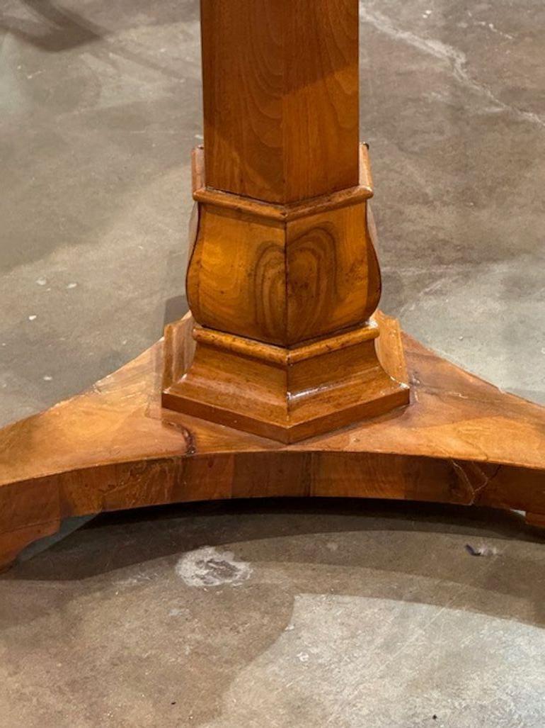 La table centrale allemande Biedermeier en noyer du XIXe siècle est un meuble rare et unique qui respire le charme historique et l'artisanat. Fabriquée en noyer de haute qualité, cette table centrale ancienne présente les détails complexes et le