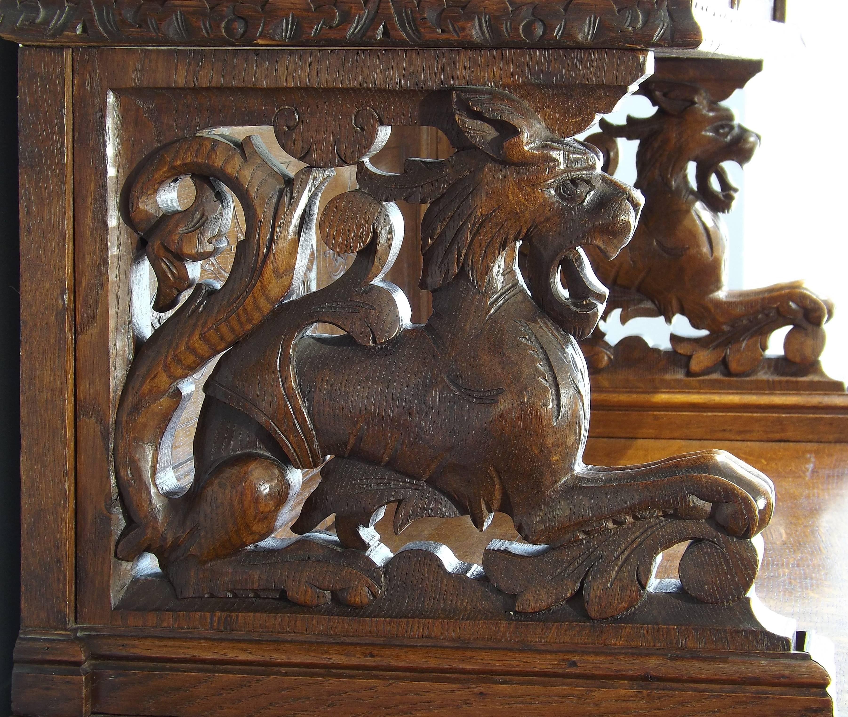 A very handsome German Black Forest cabinet, carved with wild game on the bottom doors. Two carved lions raise the top half of the cabinet to allow for a serving surface, glass doors allow for the display of fine china or other collectibles.