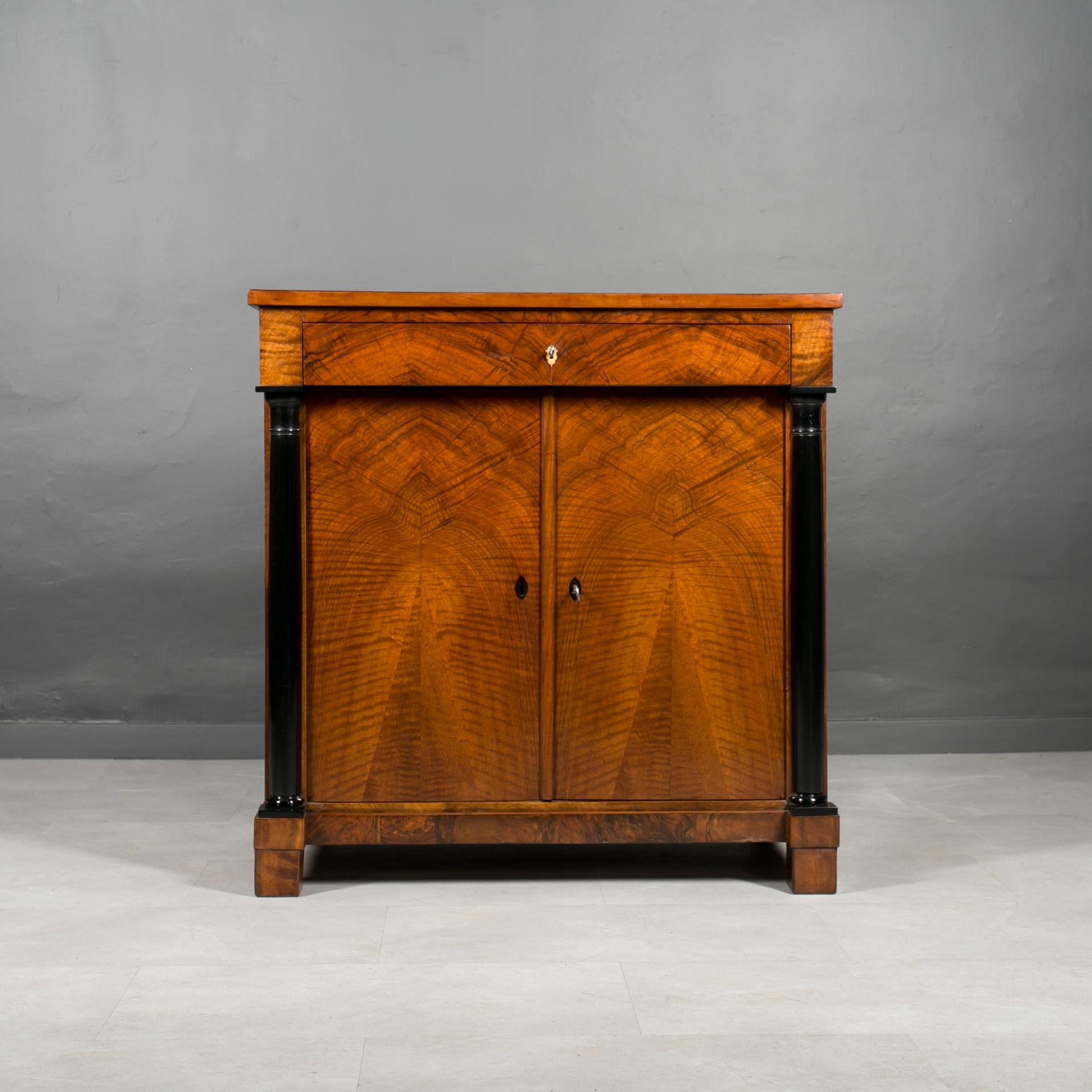 Discover a timeless treasure with this exquisite German cabinet dating back to 19th Century. Crafted from durable coniferous wood and adorned with stunning walnut veneer, this piece exudes elegance and craftsmanship. Meticulously restored, the