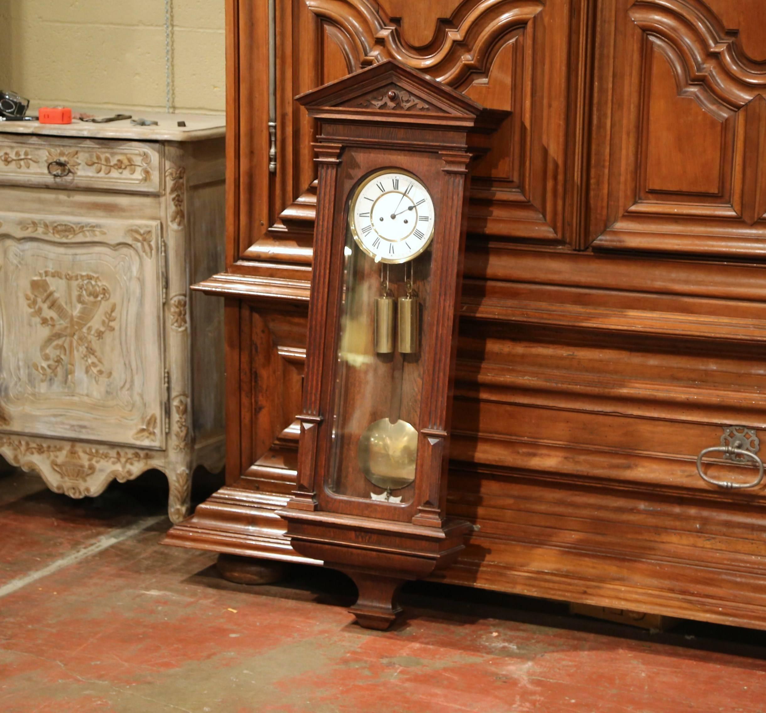 This tall wall hanging clock was crafted in Germany, circa 1870. Made in oak, the Lenzkirch clock features hand-carved decoration at the pediment and sits on an attached bracket at the bottom. The piece is in excellent condition with a rich walnut