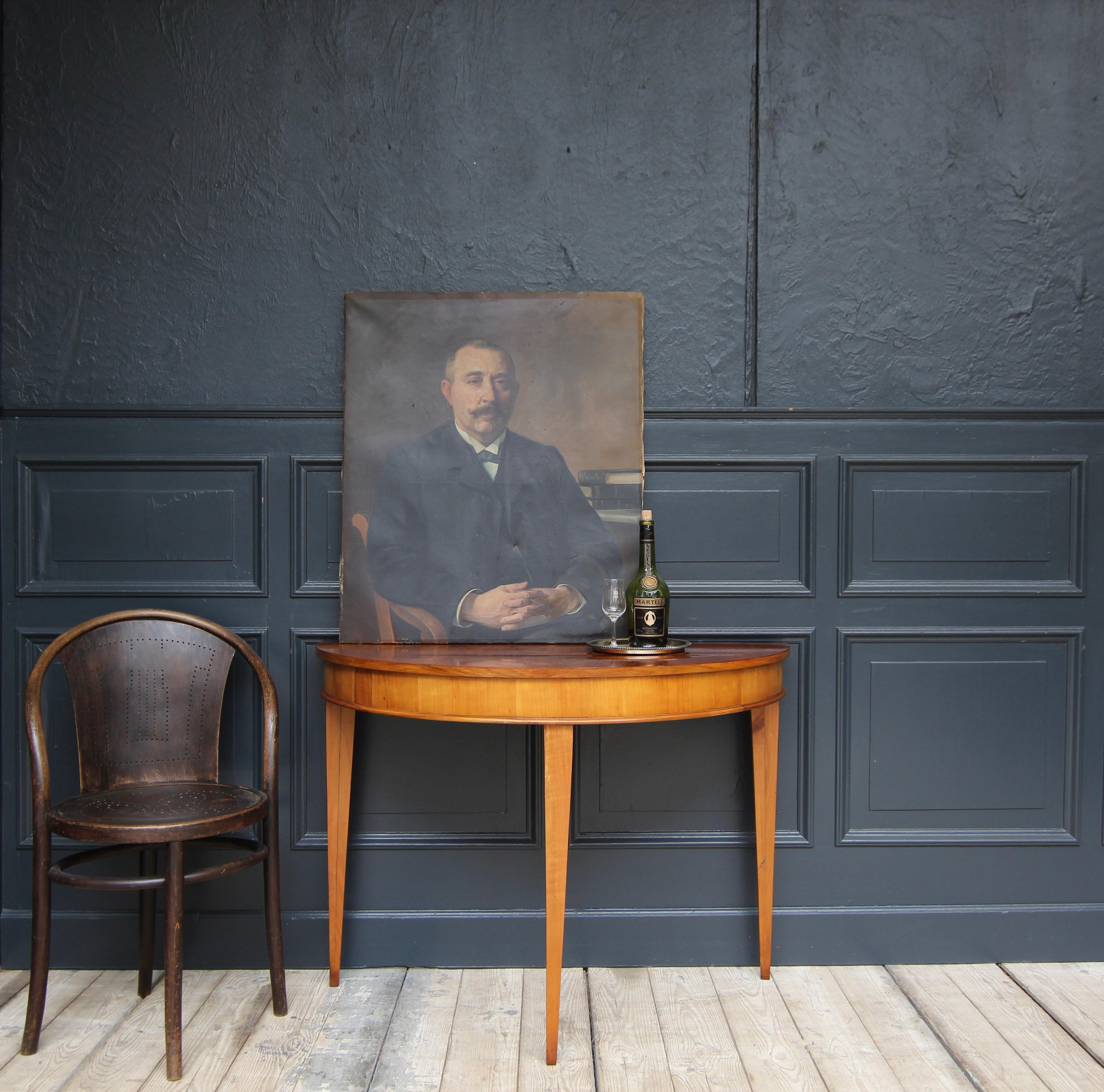 Elegant Biedermeier demi lune console table or wall table from the 1st half of the 19th century. Solid cherry wood and veneered on pine. 

Standing on 3 conical square legs with a frame and a slightly overhanging top.

Dimensions: 
75,5 cm high /