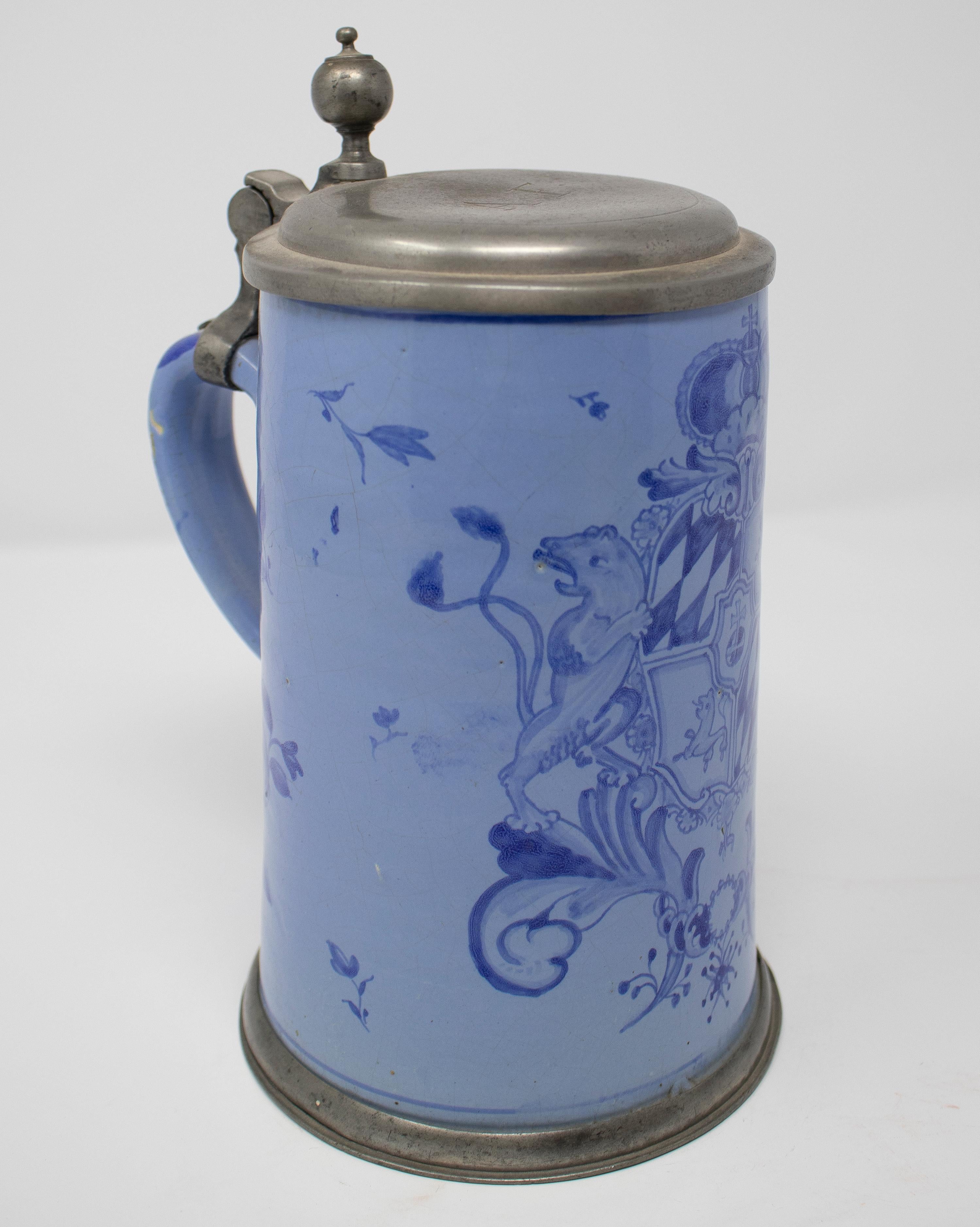19th century German earthenware beer stein mug with tin lid and cobalt blue plant decoration.