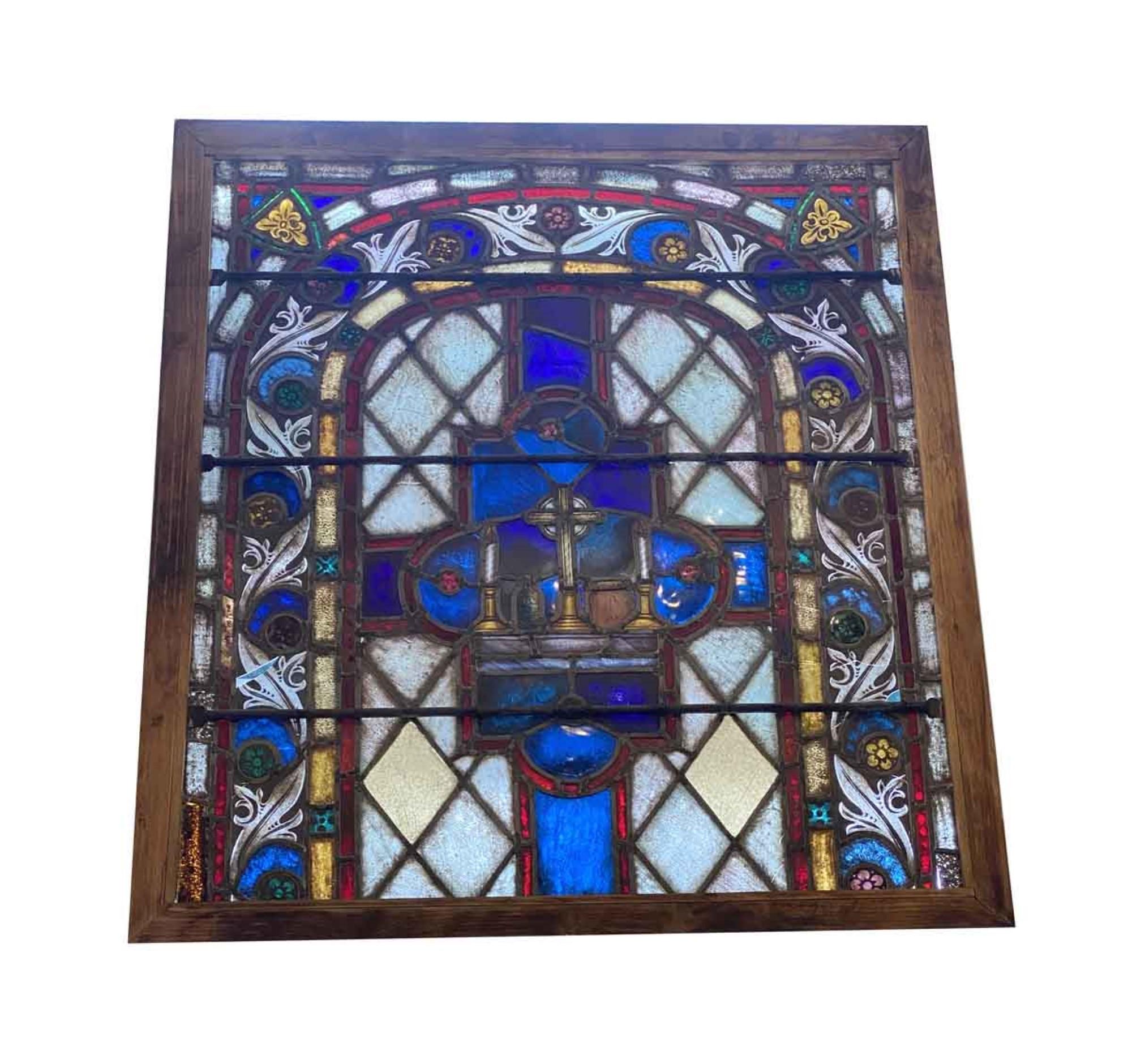 This 19th century antique wood framed stained glass window from Germany. Originally this was in a larger church window but was reframed in a smaller frame. Featuring very deep and vibrant blue, red and yellow colors. Some damage as shown in the