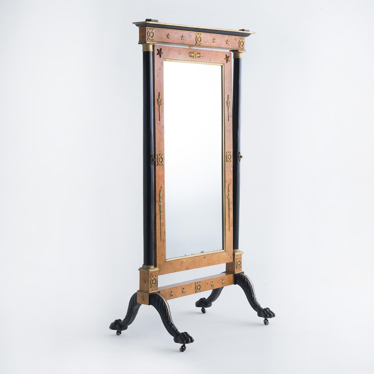An early 19th Century, antique German floor mirror made of hand crafted polished, partly veneered Cherrywood in good condition. The tall freestanding mirror is consisting its original mirrored glass, particularized on each side by a black shellac