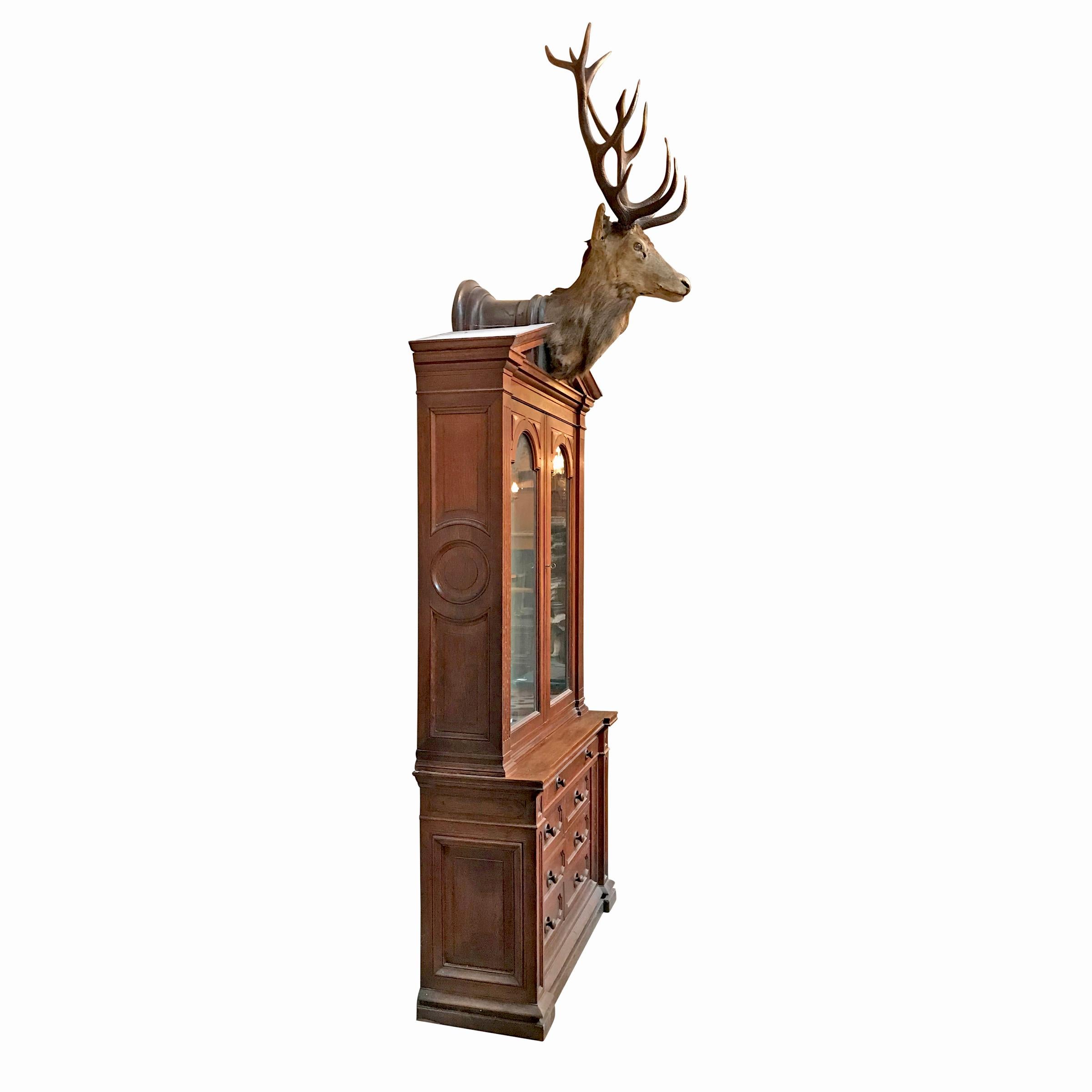 A fantastic late 19th century German oak breakfront gun cabinet with a large thirteen-point stag head trophy mount fitted to the classical Grecian pediment. The cabinet was built by German cabinet maker Carl Hottenroth. The cabinet features two