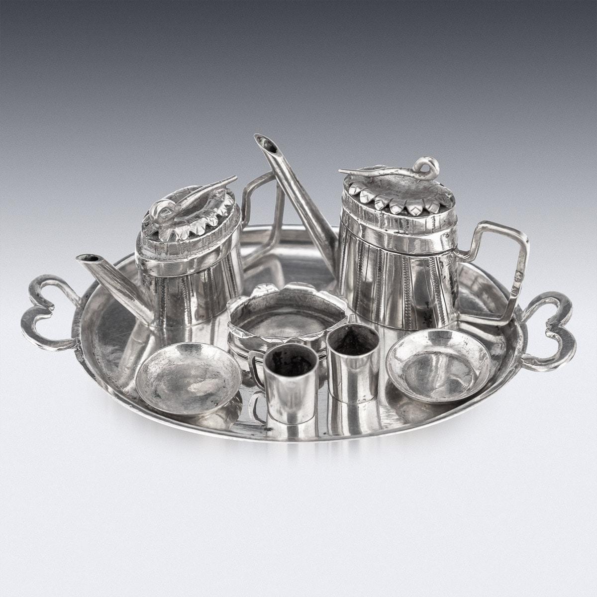 Antique mid-19th Century German miniature solid silver eight piece tea & coffee service, comprising of a coffee pot, tea pot, sugar bowl and two cups with saucers and a serving tray. A very rare set used to decorate a table in a doll house, comes in