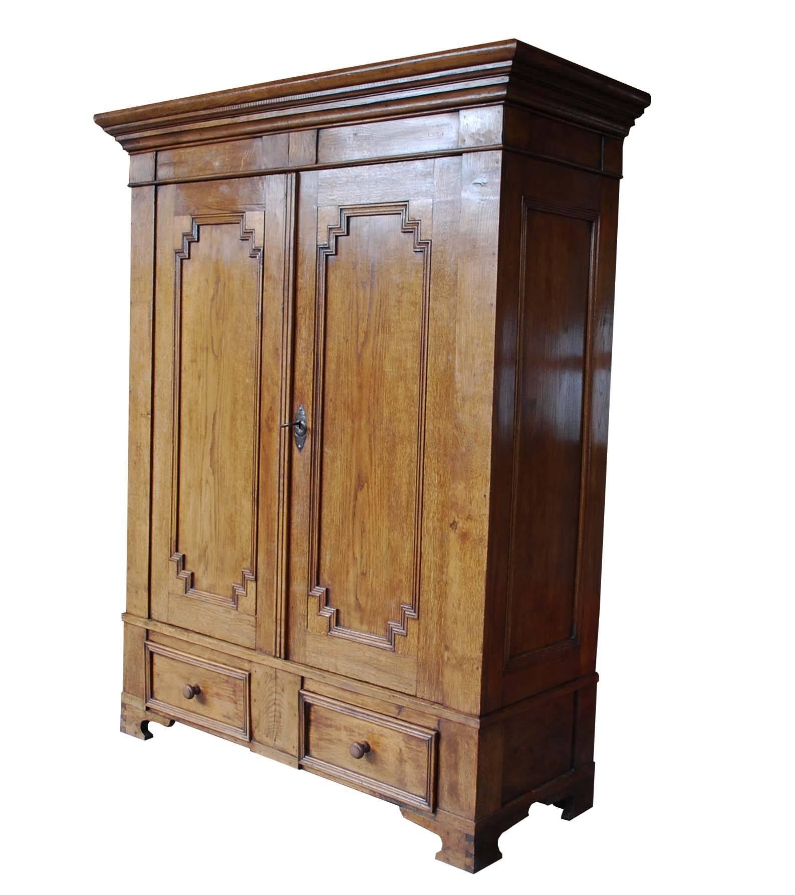 This solid oakwood cabinet originates in the German state of Nortrein Westphalen and it dates circa 1850. The cabinet can be disassembled in pieces. The cabinet has two drawers with wooden knobs and two doors. On the interior there are two fixed