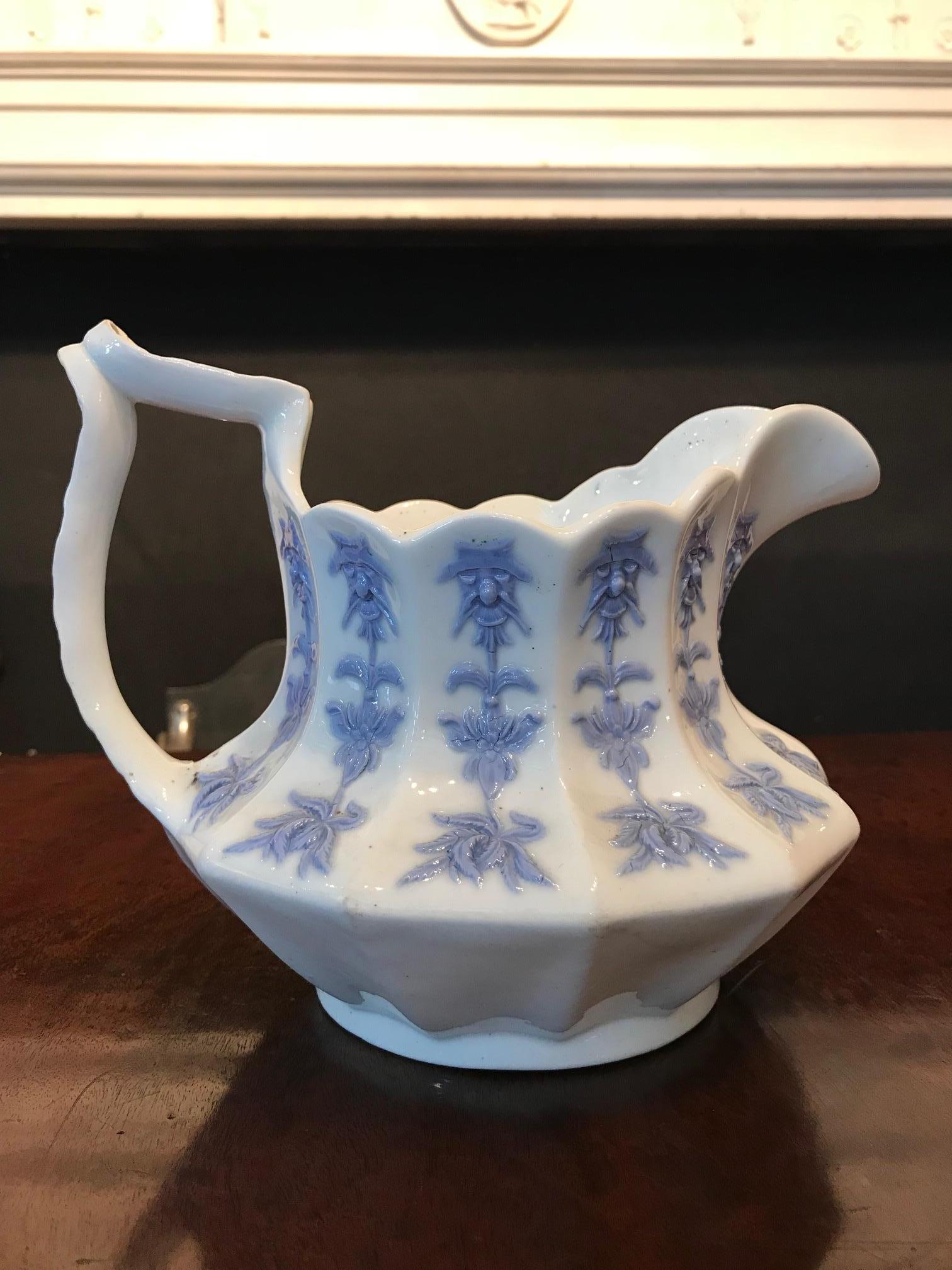 19th century German pair of porcelain blue and white jugs, the scalloped rim raised over body of baluster form with scrolling acanthus leaf handle decorated throughout with foliate and figural motif.