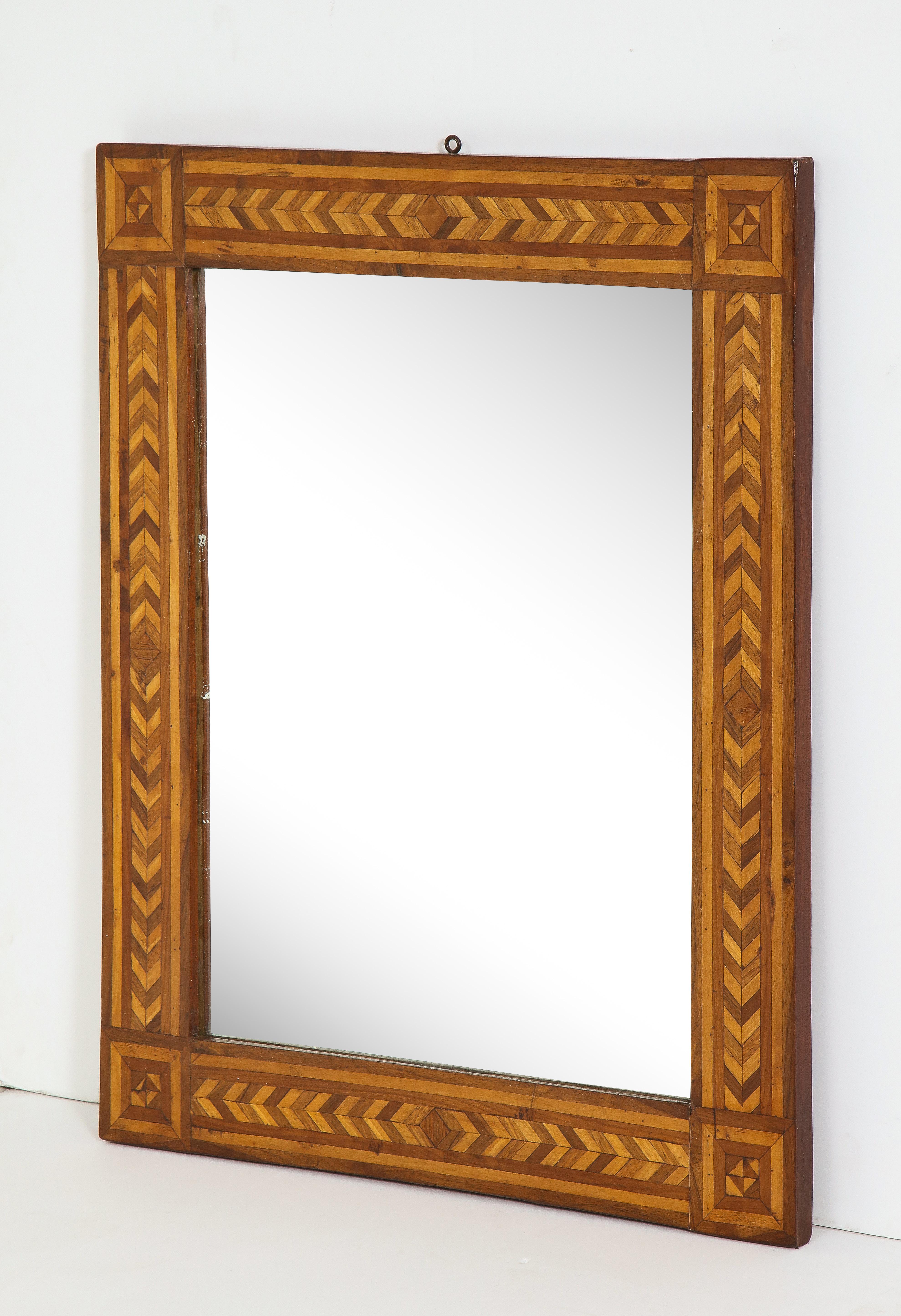 19th century German high rectangular, inlaid geometric parquetry wall mirror made of walnut and other hardwoods. Hanging loop visible at top.