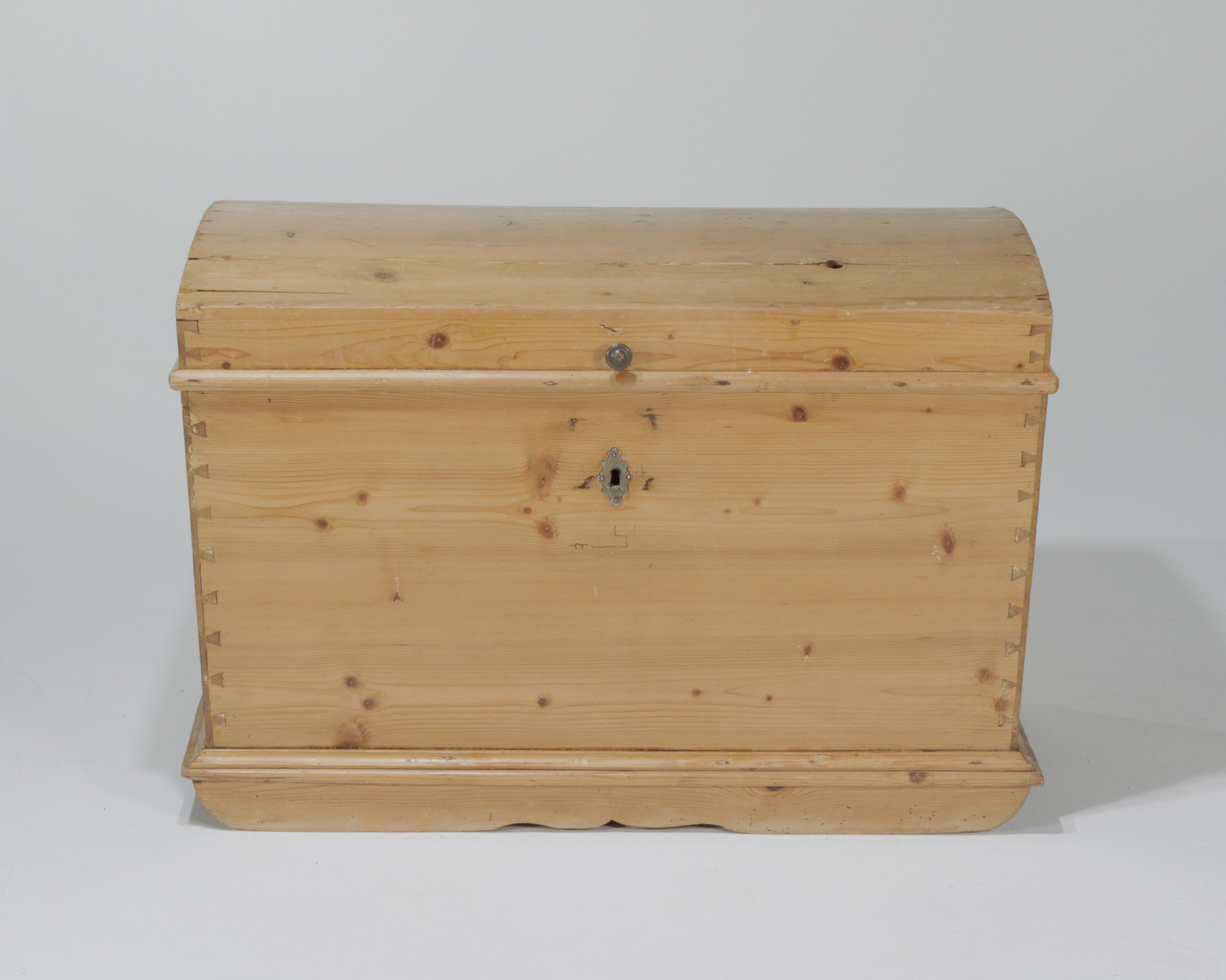 Natural pine domed shaped blanket chest with aged patina, dovetailed sides, brass and iron hardware, and lots of rustic character.