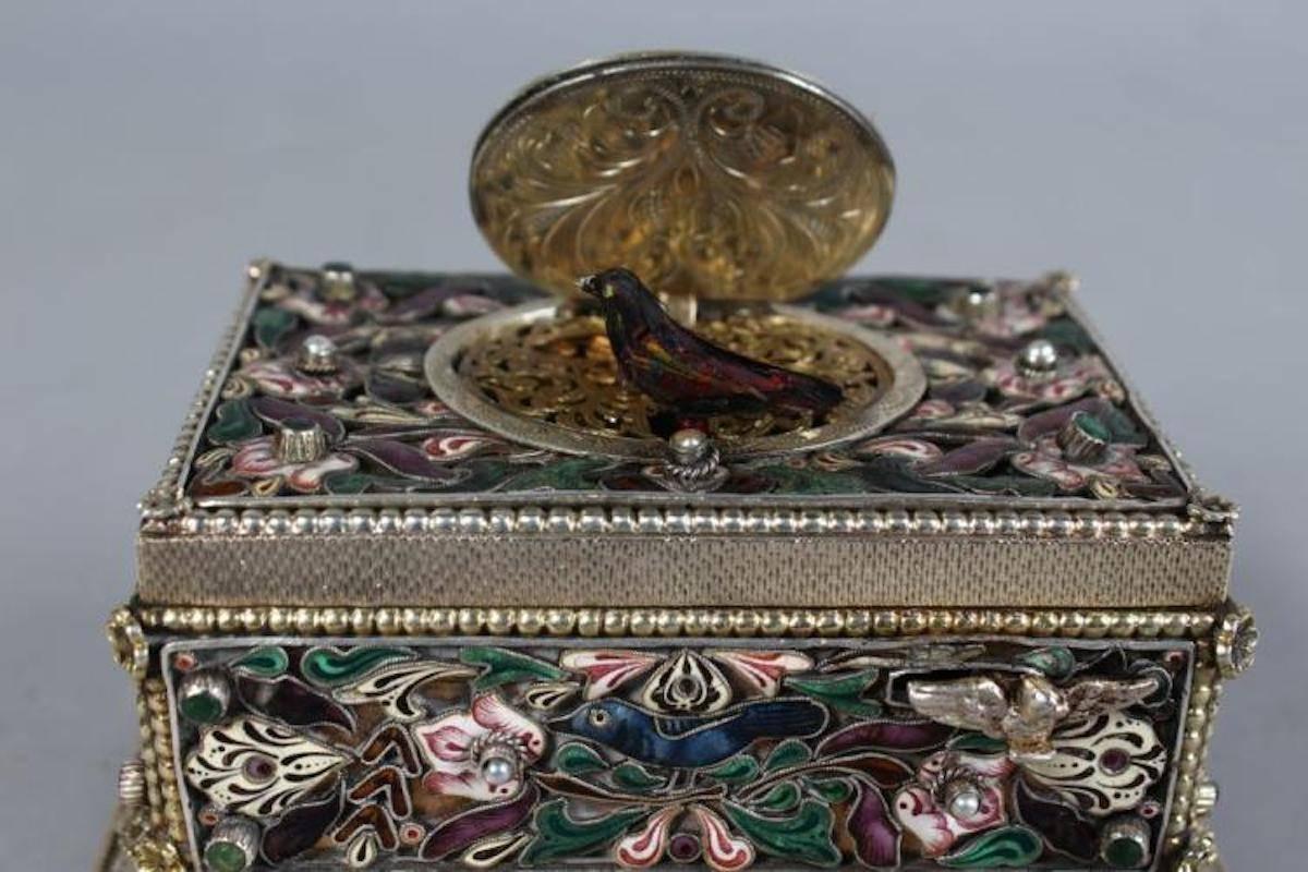 A superb 19th century German silver and enamel table singing bird musical box, with oval enamel flip up top revealing a singing bird, small sliding drawer to the base, the silver gilt case engraved and with enamel decoration (in working order with