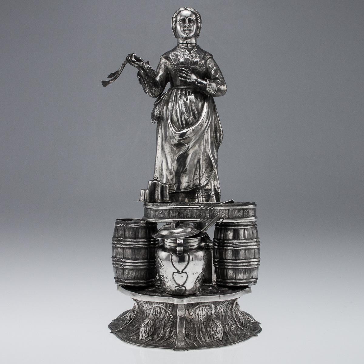 Antique 19th century German solid silver figural table ornament modelled as a female fishmonger, standing on a large shaped-oval base decorated with flowers, the large sculpture is very large and beautifully modelled, the right hand holding an eel,