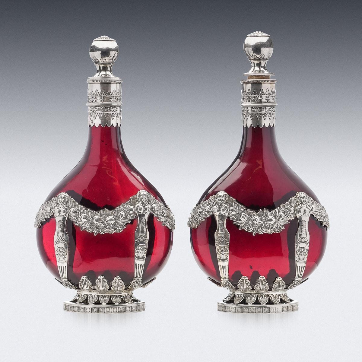 Antique late 19th Century German pair of ruby red decanters, beautifully applied with silver floral bands, surmounted by two ball shaped stoppers. Hallmarked German silver (800 standard), Makers mark ‘KKK’ for Karl Kurz.

CONDITION
In Great
