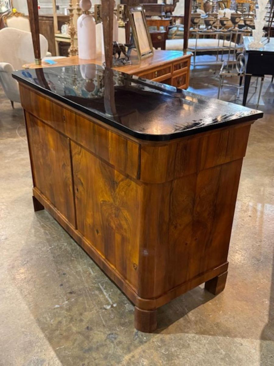 This 19th century German walnut and black lacquered Biedermeier commode is a classic piece of antique furniture. Its elegant design and finely crafted details make it a timeless addition to any home decor. The commode showcases the craftsmanship of