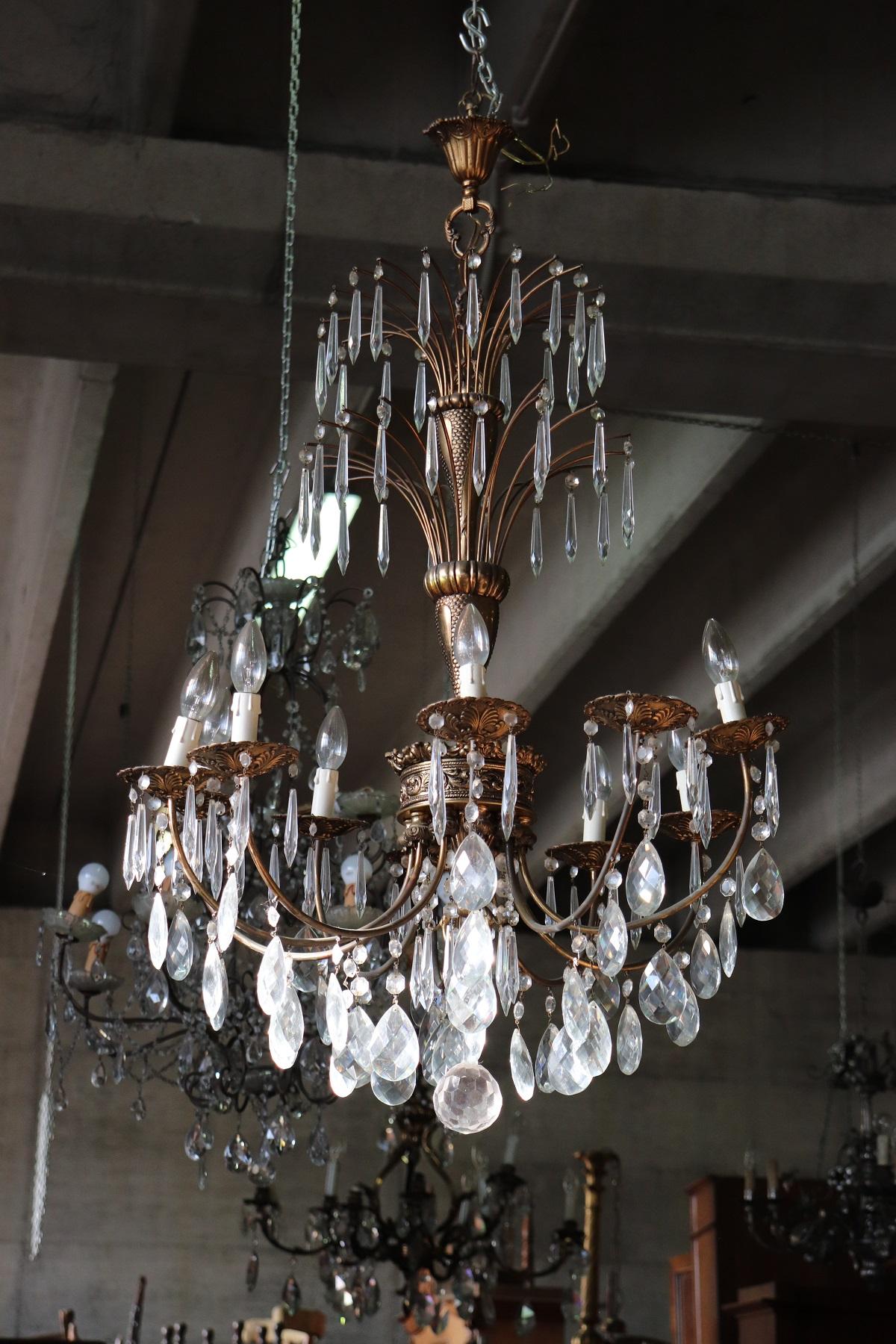 Beautiful and refined Italian antique pair of chandeliers ten-light. In gilded bronze and completely covered drops of crystal. The crystal exudes the typical brightness; the drops are finely worked giving an elegant light. The drops are worked with