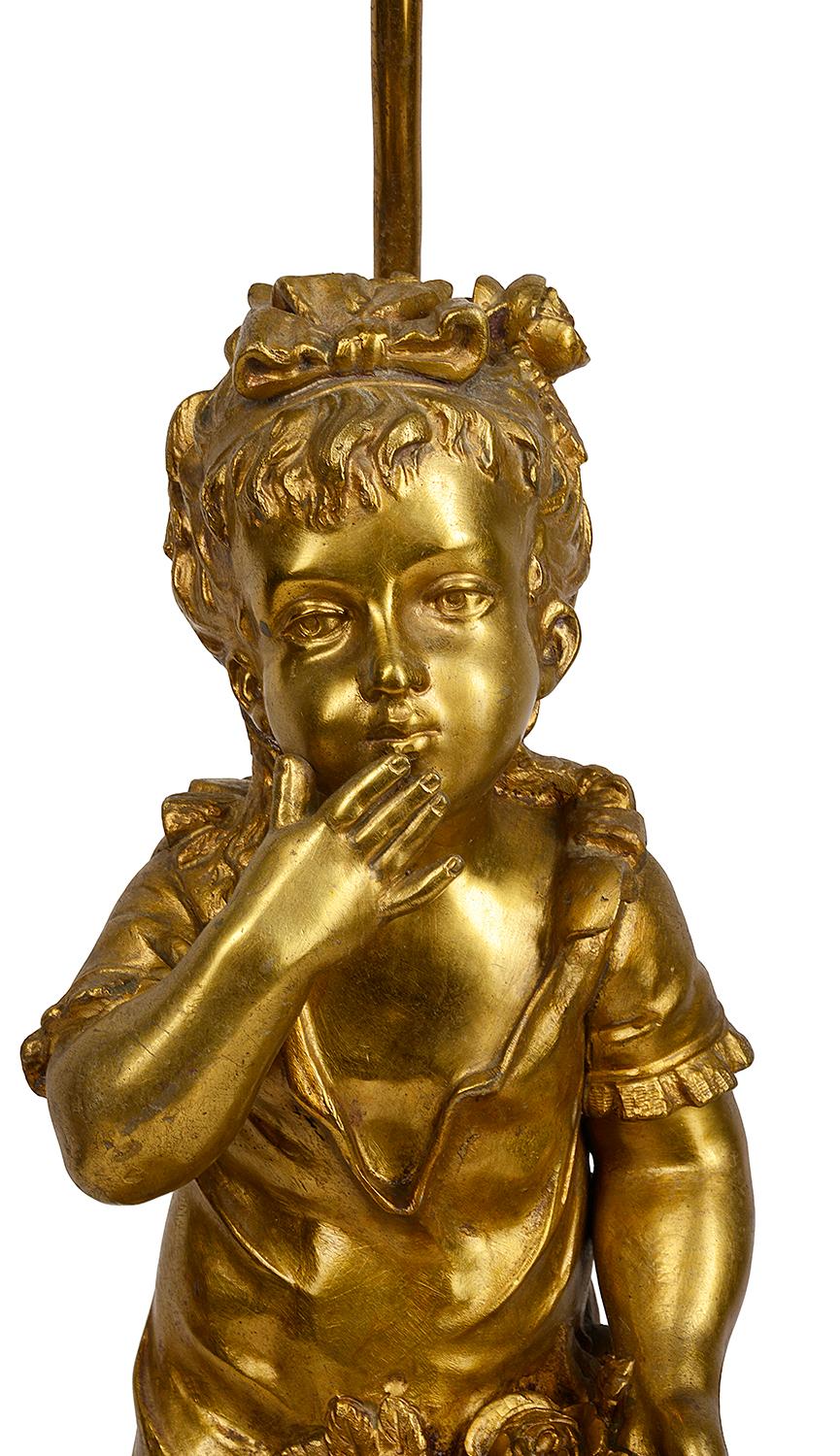 A very good quality late 19th century gilded bronze statue of a young girl blowing a kiss and holding flowers she's picked in her dress. Mounted on a grey marble base with a lamp fitting behind.
Signed, A. Vilair.