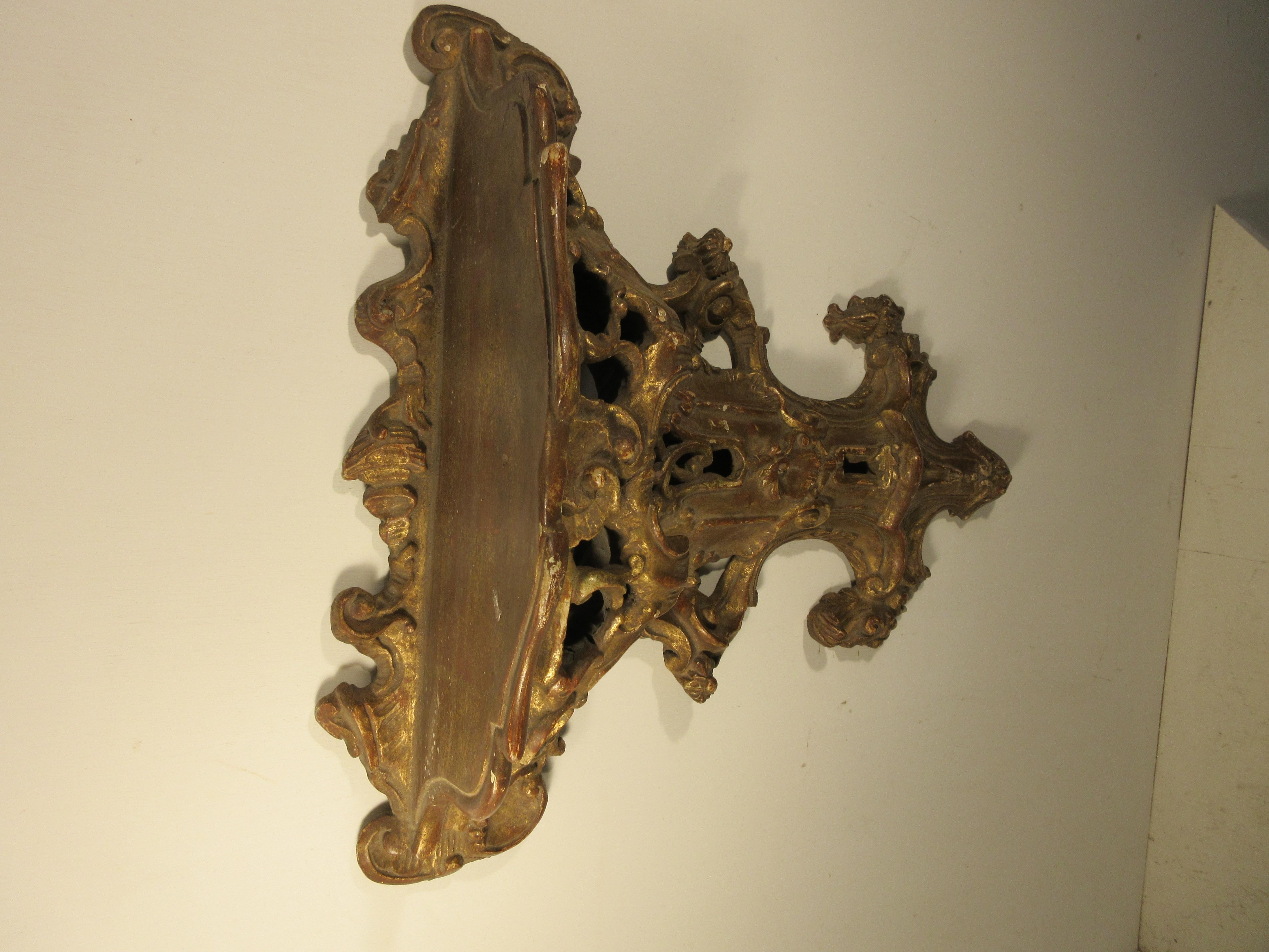 19th century Italian gilded shelf hand carved in wood. Wonderful detail and good patina found on this beautiful .Rococo style wall shelf.